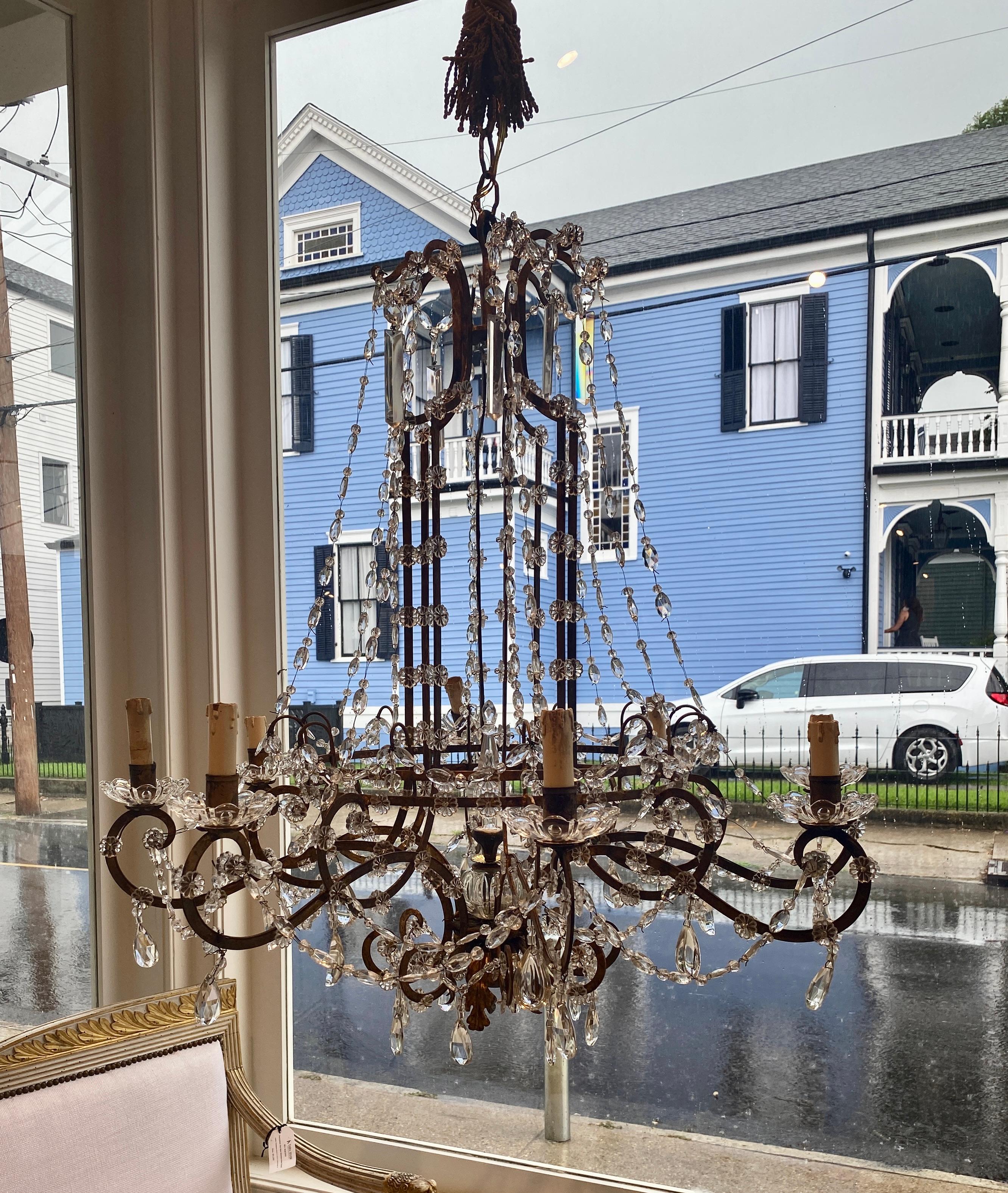 Elegante e senza tempo, questo lampadario italiano in ferro e cristallo del XIX secolo presenta una struttura in ferro splendidamente invecchiata e ornata da cascate di gocce di cristallo tagliate a mano, ghirlande e fiori. Il design a otto luci,