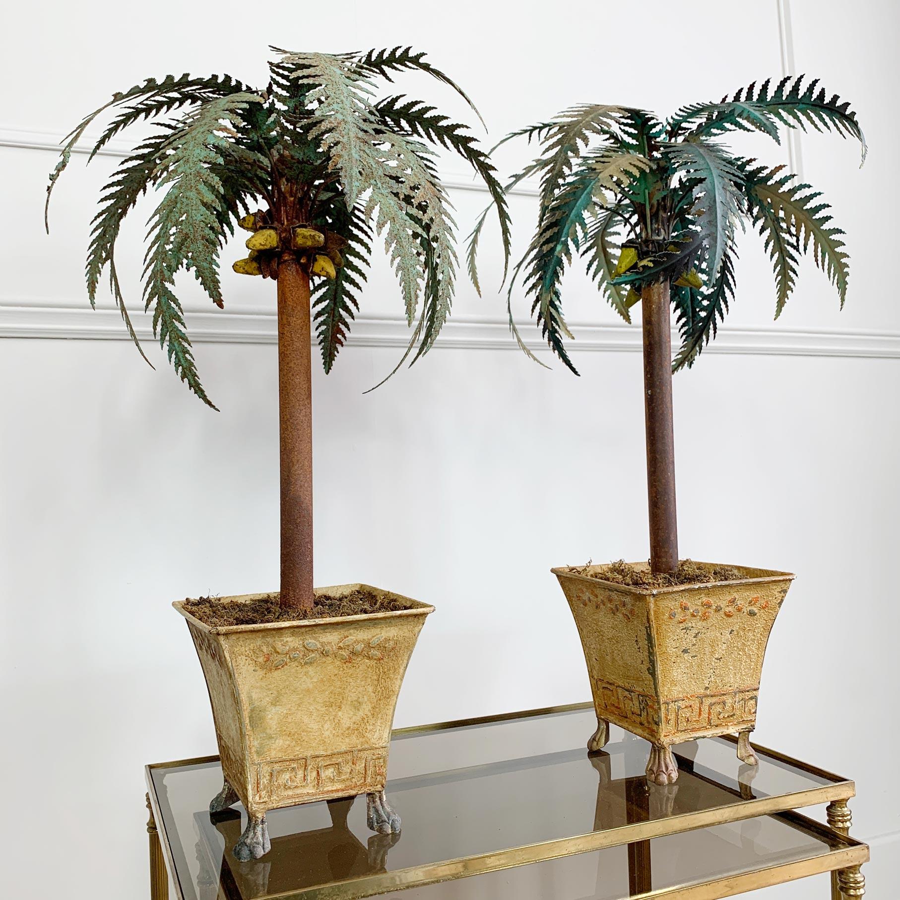 An exceptional pair of hand painted antique metal palm trees, made in Italy circa 1870, very intricate detailing and painted decoration. The pair are set within small moss topped planters that sit upon lion paw feet. The palm leaves sit above a