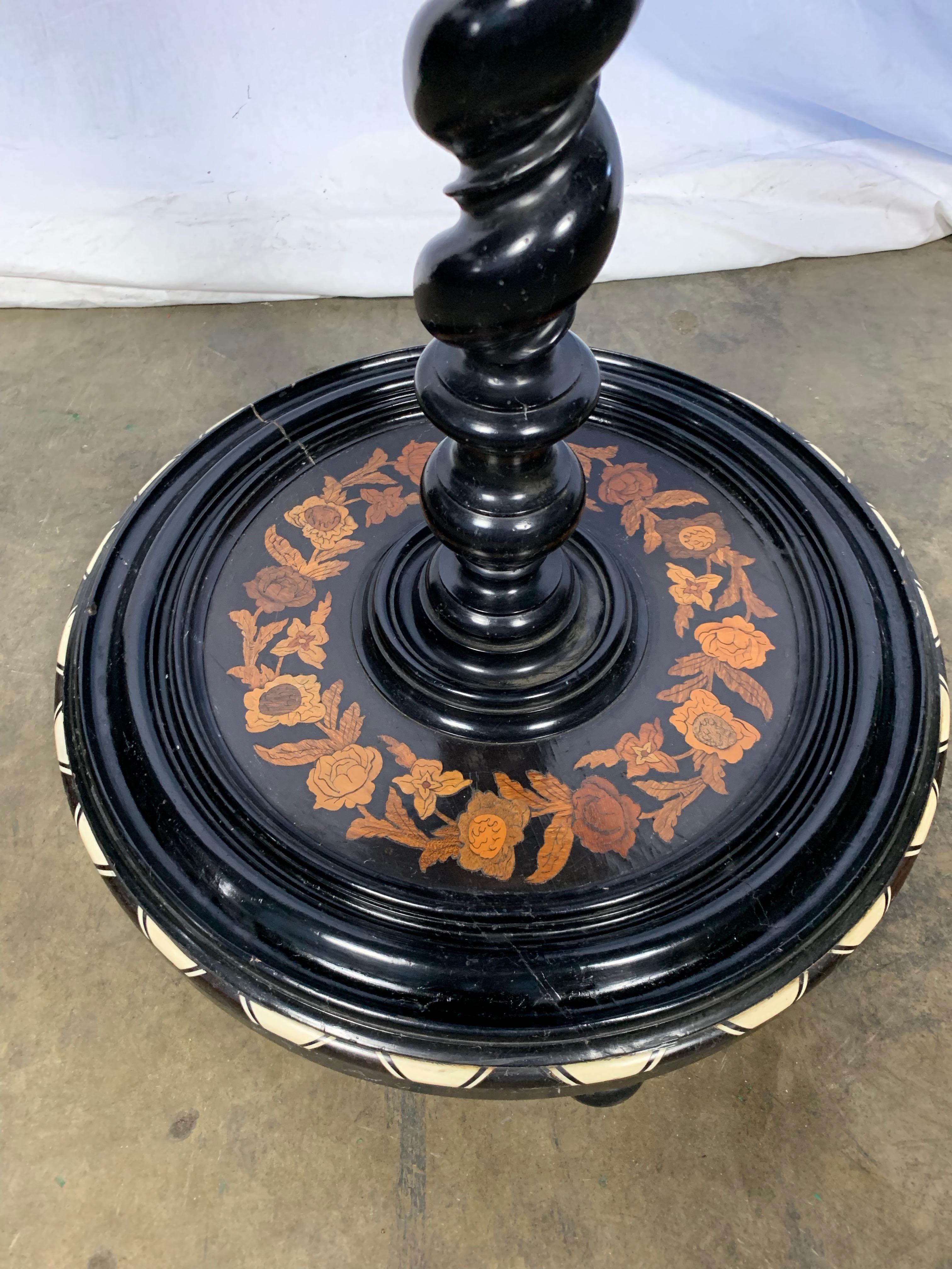An unusual Italian ebonised and marquetry inlaid occasional table. Late 19th century. The circular top profusely decorated with flowering foliage. Worth rope twist column and circular base.