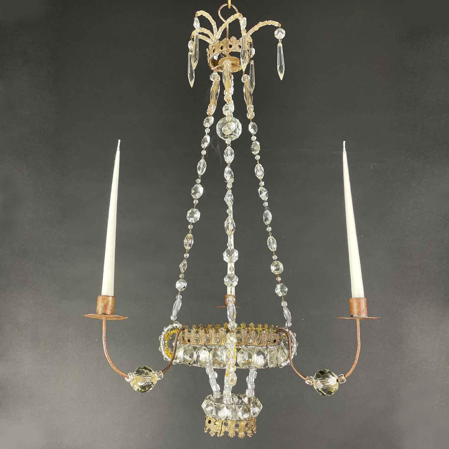 A charming classical Empire Italian chandelier born for candle lighting, featuring three arms ending with candles, no electric wiring, can be used as candle holders or decorative candelabra.
From Marche, a region in Central Italy, a romantic fully