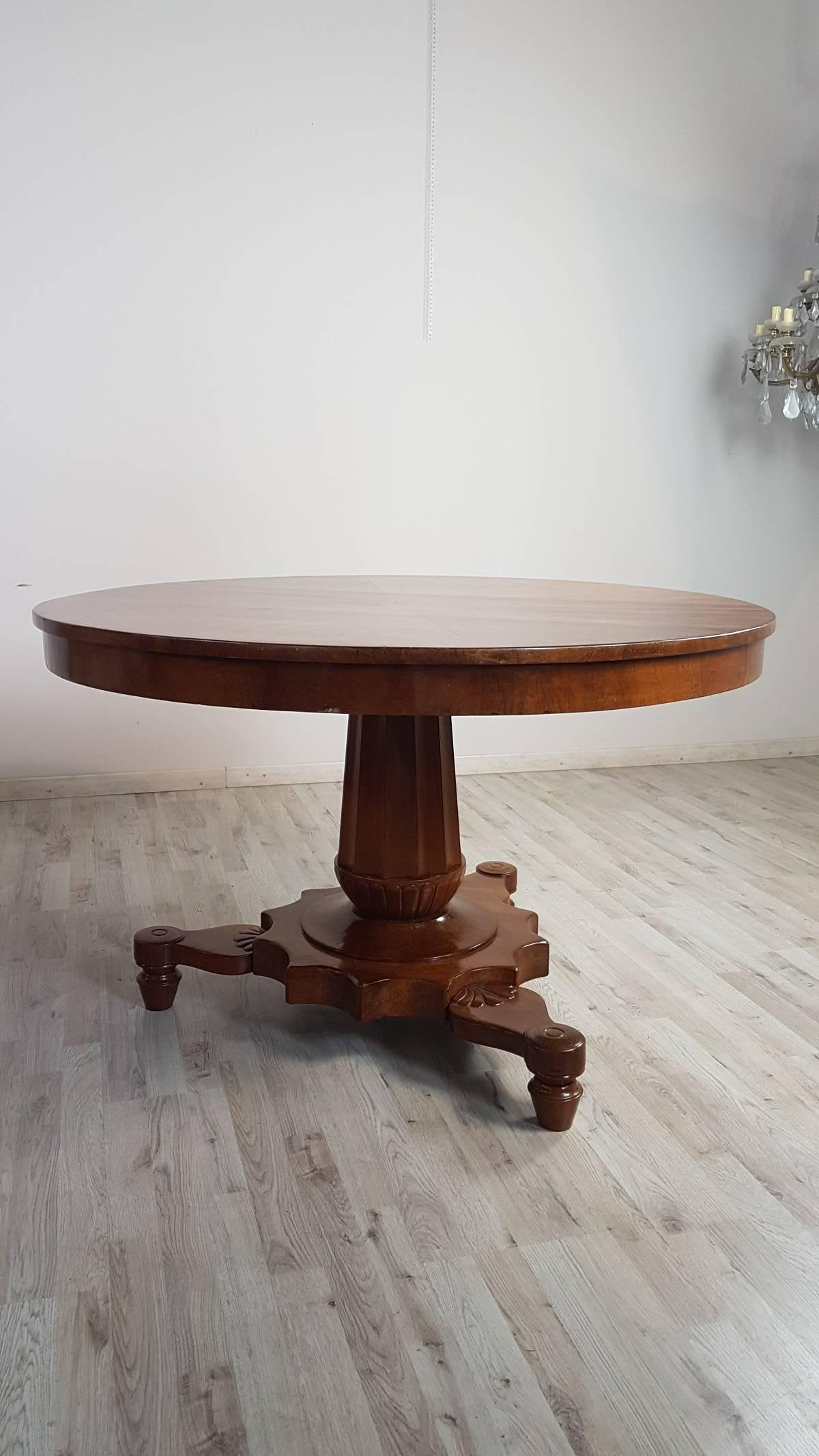 Beautiful important Empire 1804s-1815s 19th century in solid walnut. Table with elegant turned central leg made from a single wooden block and delicate feet with carved decoration palm . The top is characterized by a narrow and comfortable band at