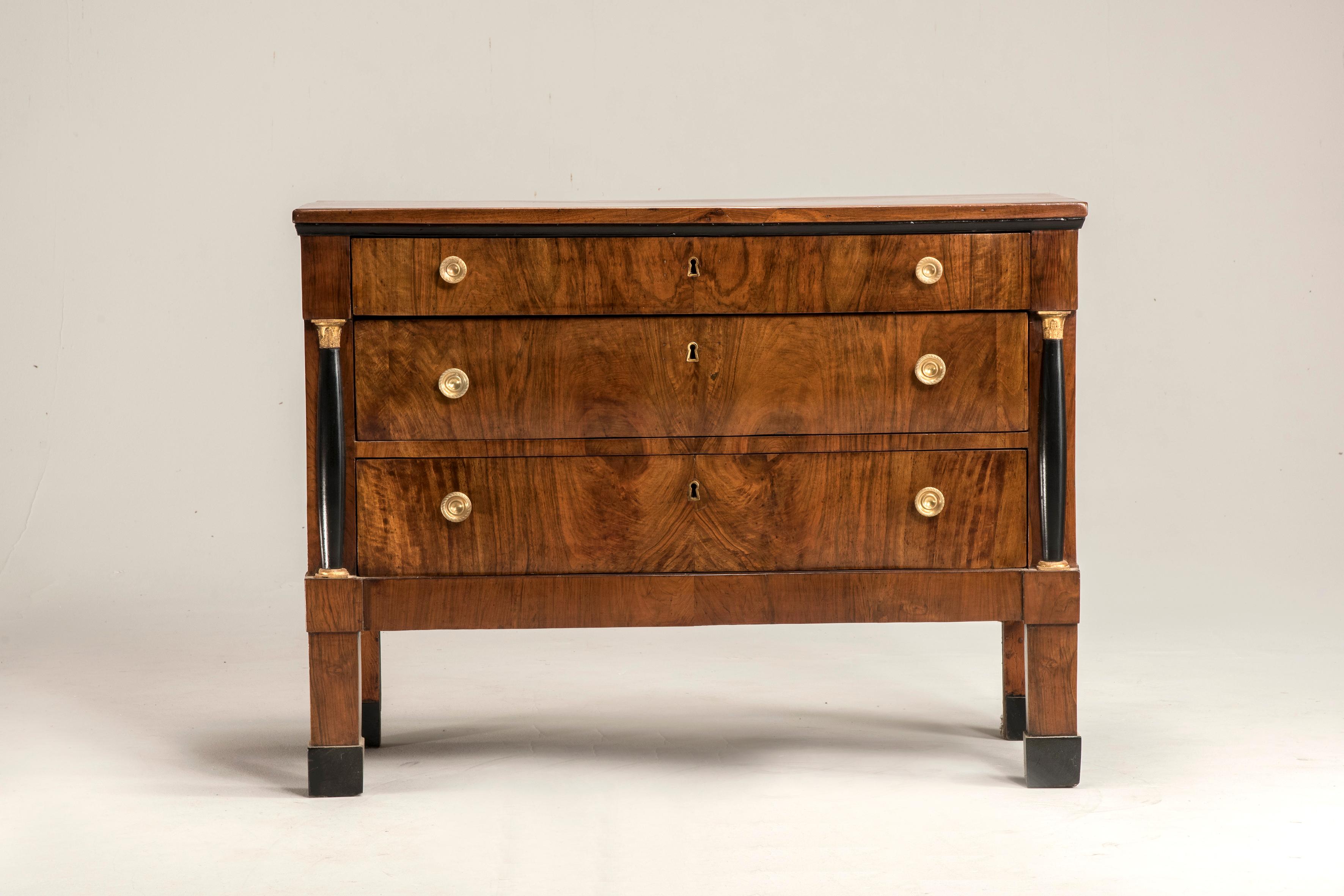 19th Century, 1810 circa Italian Empire Walnut Wood Chest of Drawers. This piece of furniture is veneered with walnut. It is from Italy from Veneto region. It features gilt wood capitals and black lacquered columns, original lockers and coeval