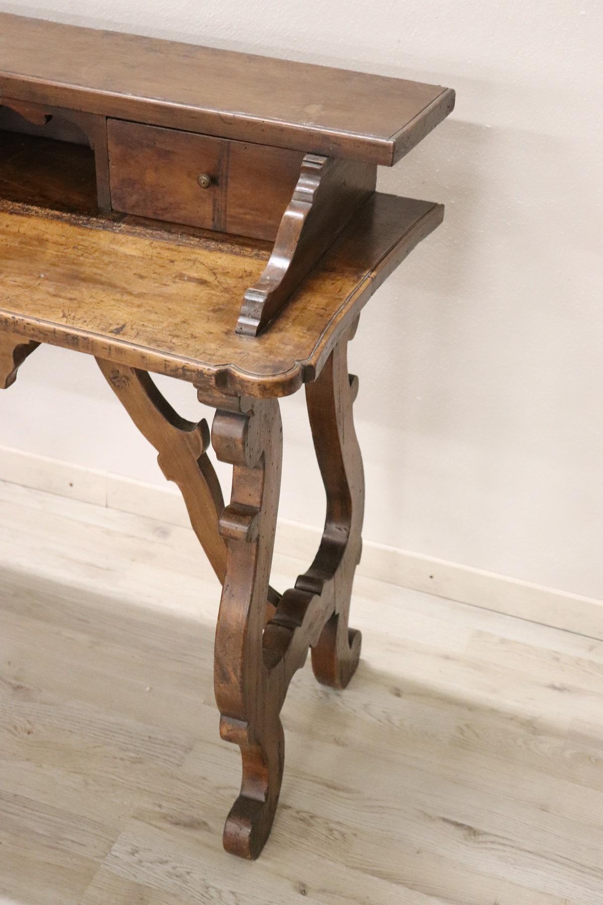 Elegant and essential antique Italian writing desk. 19th century Renaissance style period with classic Lyre legs. On the front it has 3 useful drawers. Rare and precious walnut. The back of the desk is rough because it is designed to be placed