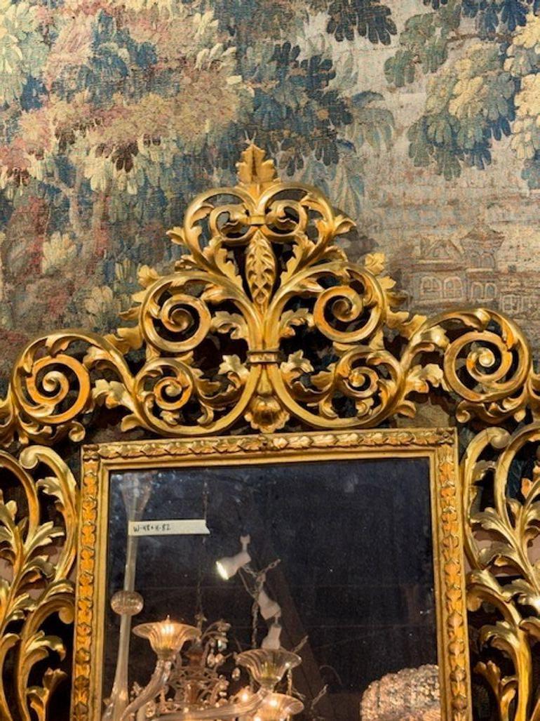 Le miroir italien Florentine du XIXe siècle, sculpté et en bois doré, respire l'opulence avec ses sculptures complexes et ses détails en bois doré, mettant en valeur le savoir-faire des artisans italiens du XIXe siècle. Le style Florentine du miroir