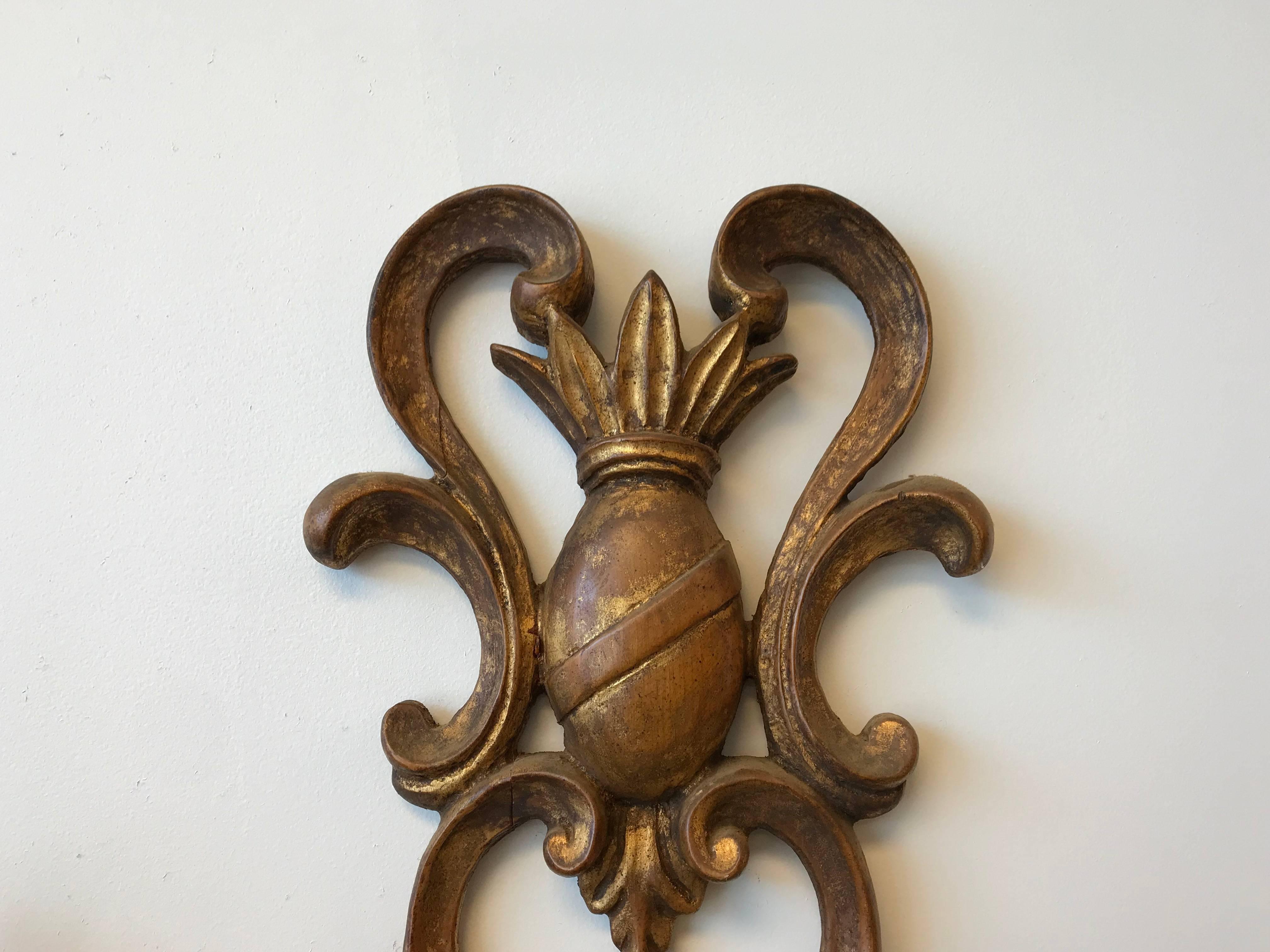 Listed is an exquisite, 19th century Italian Florentine gilded wooden, four-arm candlestick wall sconce. The piece has a lovely pineapple crest motif at the top.
