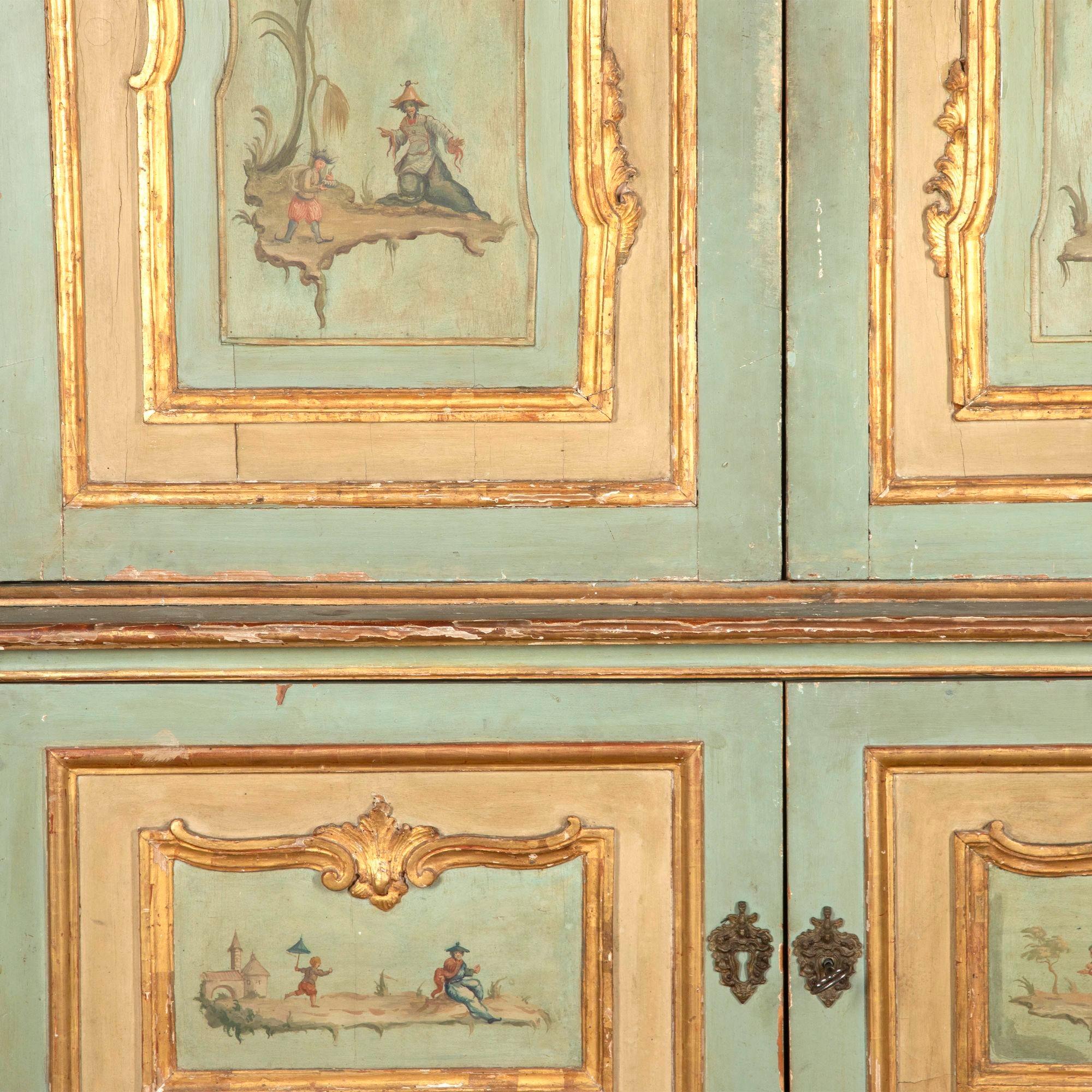 Early 19th Century Italian four-door painted cupboard of 'palazzi' proportions with original green paint.
In carved giltwood mounts and hand-painted chinoiserie. The base is one piece and the top dismantles.
With signs of wear, commensurate with