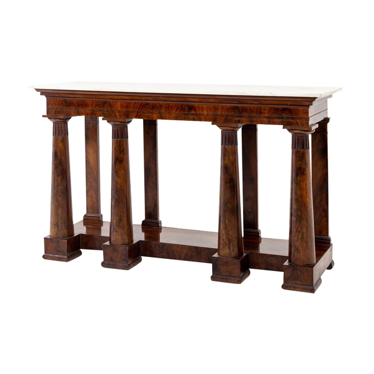 A dark-brown, antique neoclassical Italian center table made of handcrafted shellac polished Mahogany, in good condition. The freestanding polished console table is composed with a white-grey marble top, standing on four columns and pilasters each,