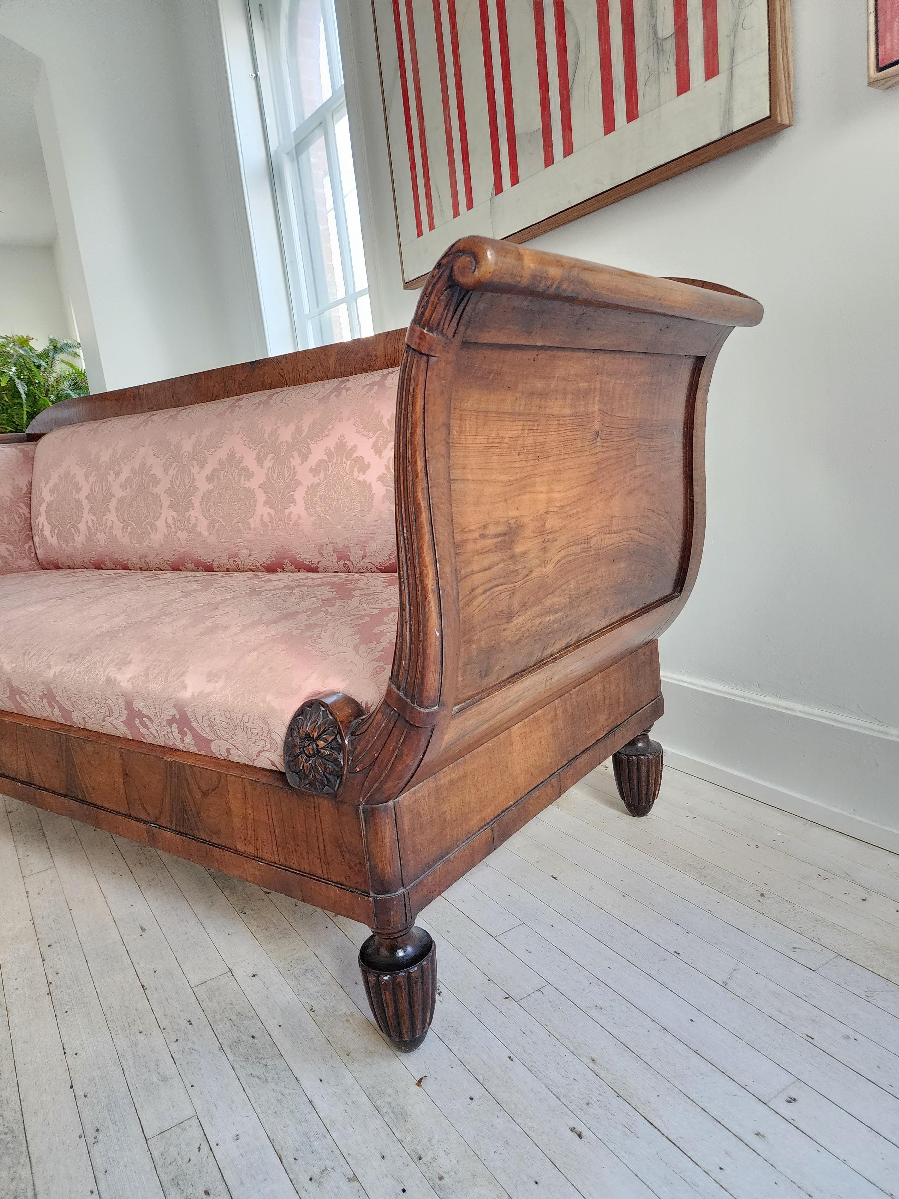 Great design, full of grace and presence. This large sofa, made in Italy, 1st half of the 19th century, is a rare find indeed. 
The beautiful carving on the fronts of the arms and how they slowly and gracefully curve back, add sense that the sofa is