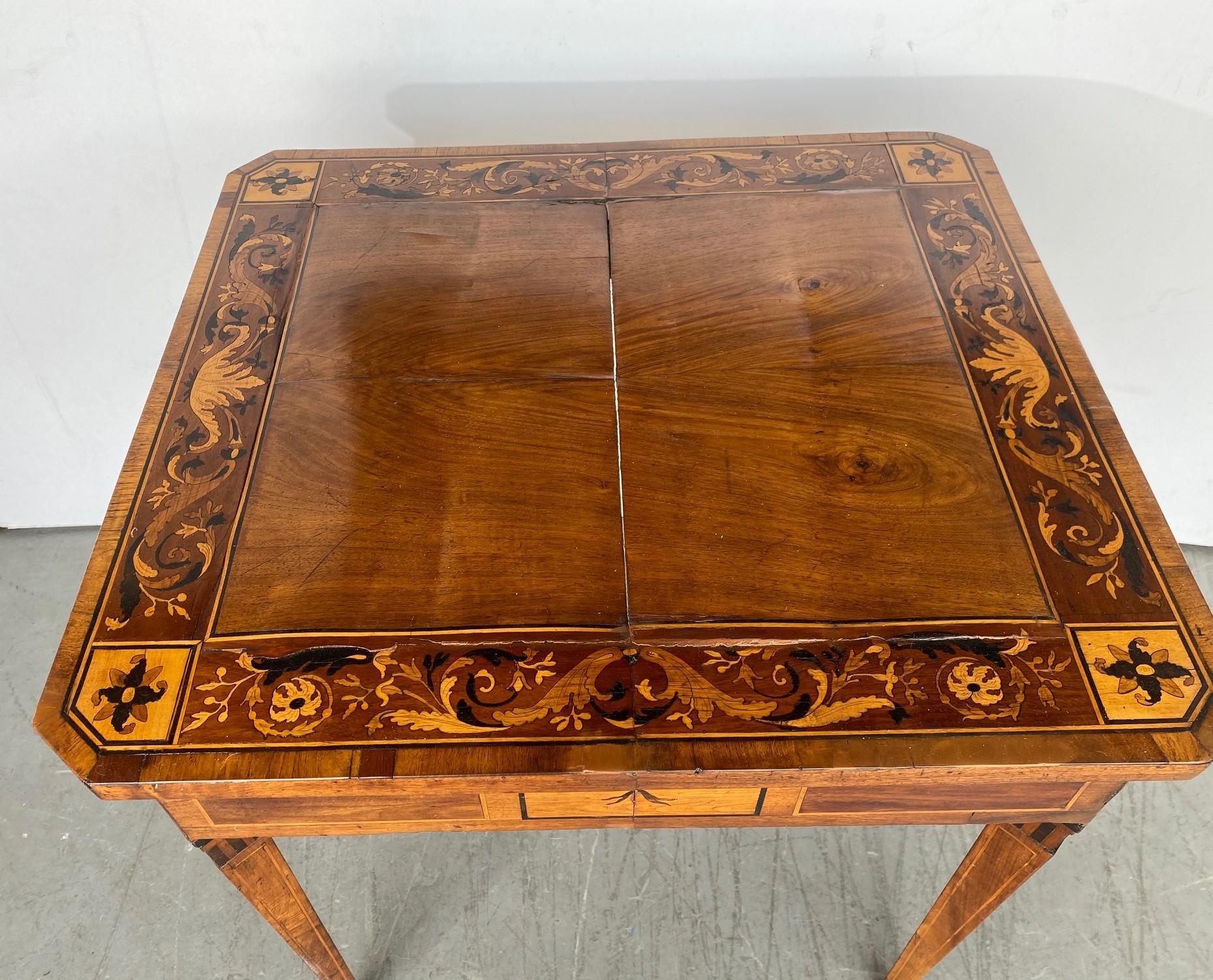  An Italian Game Table in various kinds of wood. Marquetry decorations with Acanthus leaf scrollwork using Ebony, Boxwood, and various other woods. Inlaid pinstriping to the legs. Some warping to the top that shows strongly under flash, see direct