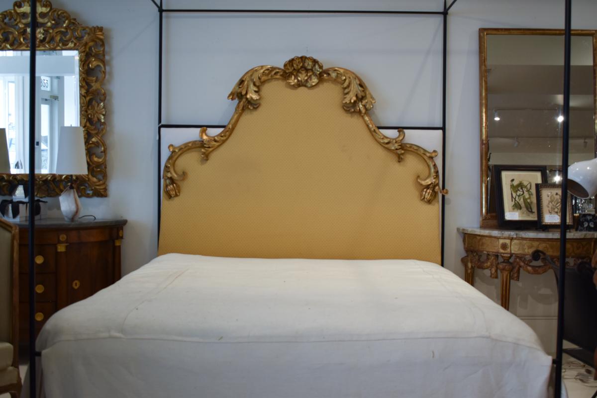 This exquisite 19th Century Italian gilded headboard is a stunning example of the luxurious and ornate design characteristic of Italian craftsmanship from this period. The headboard features an elaborate and gracefully curved silhouette, crowned