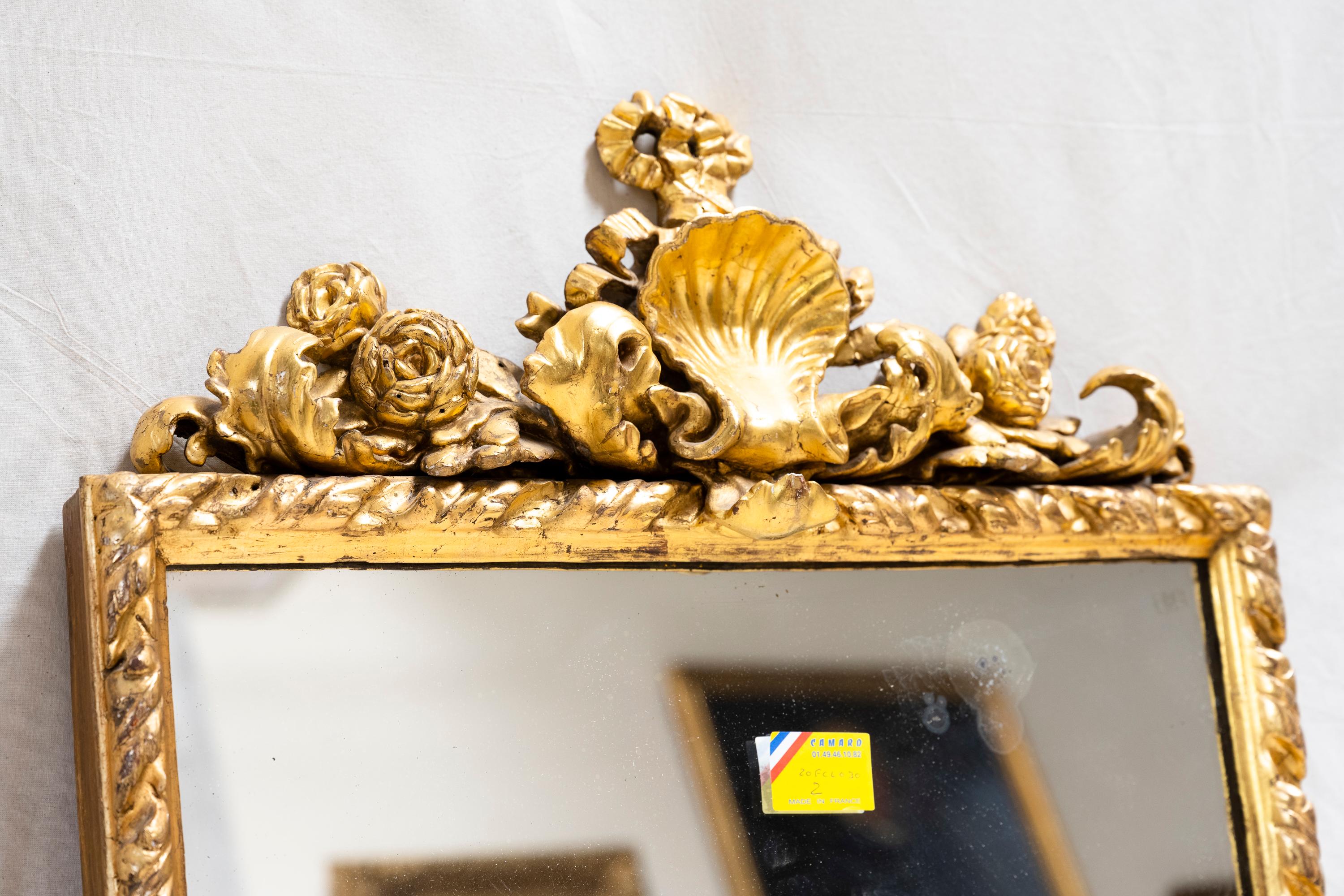 Miroir italien en bois doré (c. 1880). Orné de camélias, de feuilles d'acanthe et de la crête d'une grande coquille, ce miroir était suspendu dans le salon d'un glorieux château. 

Provenance : Un château près d'Albi, France.