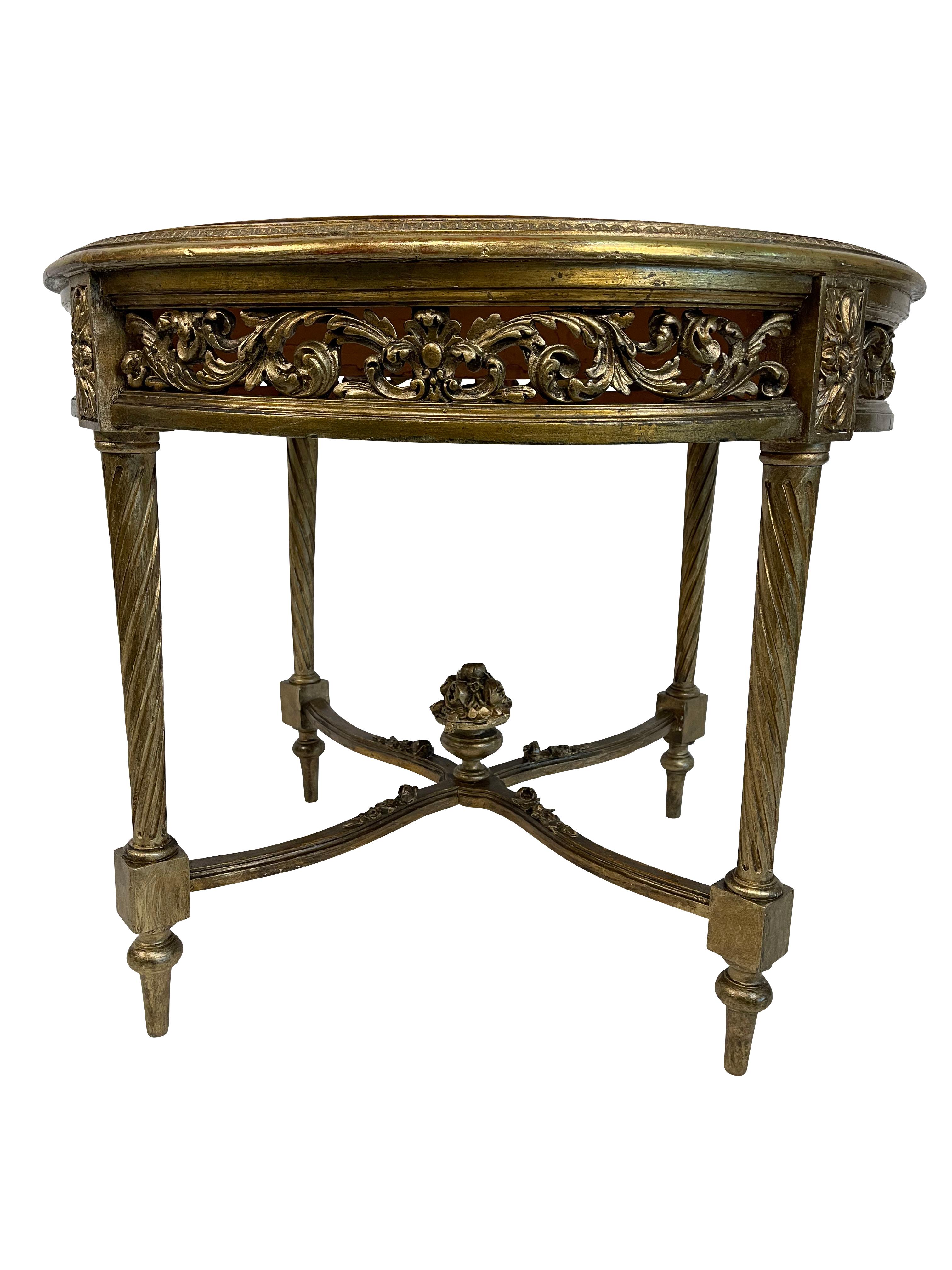 This table is an antique classical Italian/French round end or center table with a giltwood finish and marble top.  It is a solid strong construction with lovely scrolled fretwork around the table aprin. the center bracket at the bottom rises to a