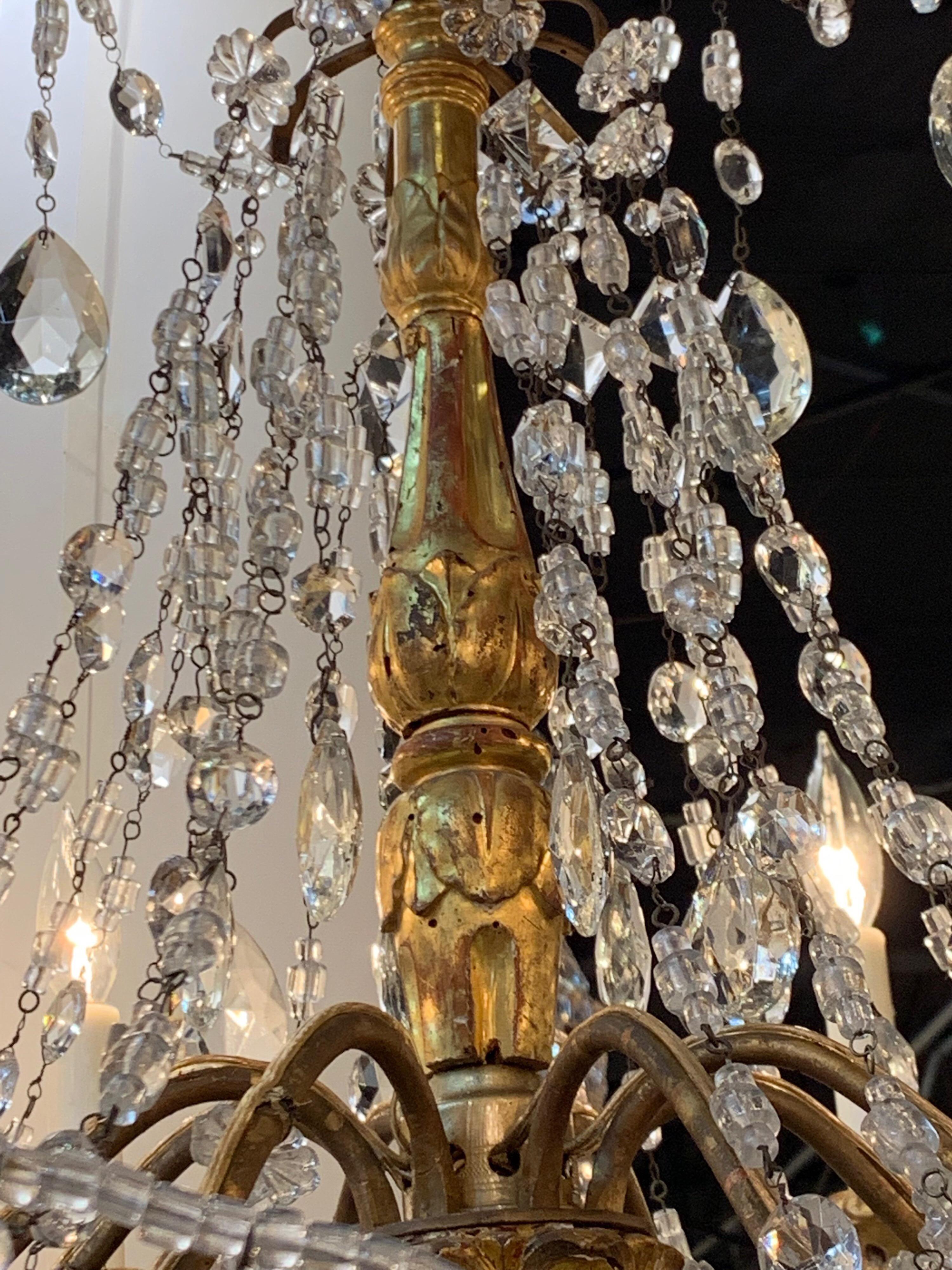 Beautiful Italian giltwood and beaded crystal chandelier. Very nice gilt and carvings on the wood with an abundance of beads and prisms. Perfect for an elegant home.