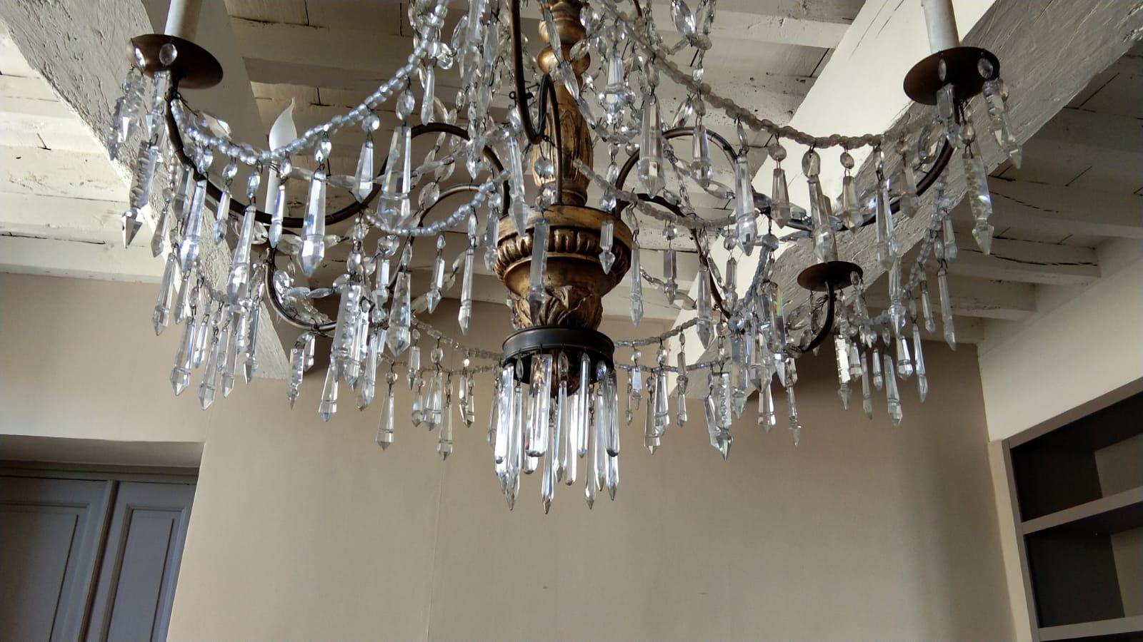 Early 19th century Italian six-arm gilt carved wood, iron and crystal chandelier. Originally candle powered and has been electrified.