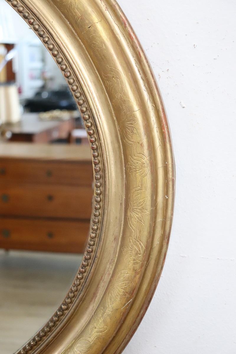 Nous vous présentons cet élégant miroir antique italien datant du milieu du 19e siècle. Un miroir extrêmement raffiné.

Réalisé avec un cadre en bois finement décoré à la feuille d'or, selon des techniques traditionnelles. Le cadre n'est pas trop