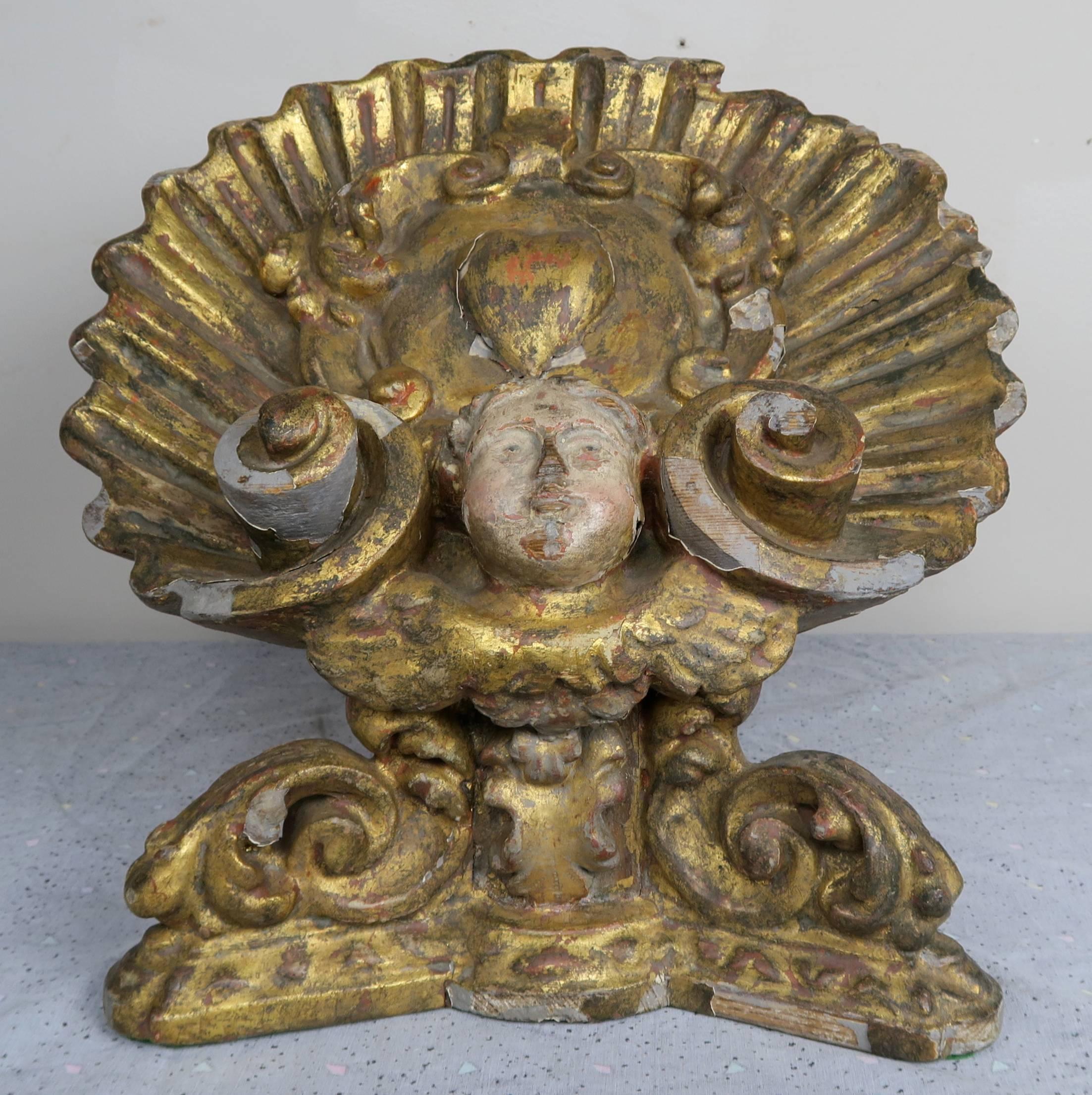 19th century carved giltwood polychromed book stand depicting a cherub face surrounded by a large shell with a sacred heart motif in the centre. Beautiful scrolls carved throughout.