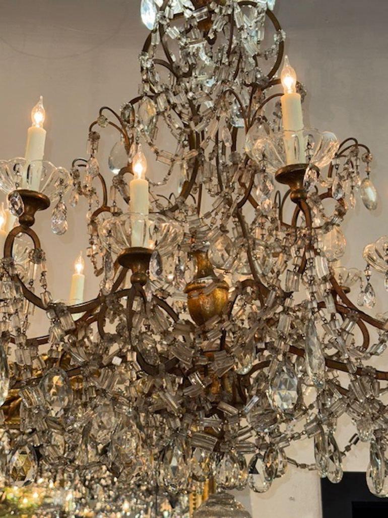 Le lustre italien du XIXe siècle en bois doré et cristal perlé est un superbe luminaire qui respire l'élégance et l'opulence. Fabriqué en bois doré et orné de cristaux perlés complexes, ce lustre témoigne d'un savoir-faire italien exquis. Ce lustre