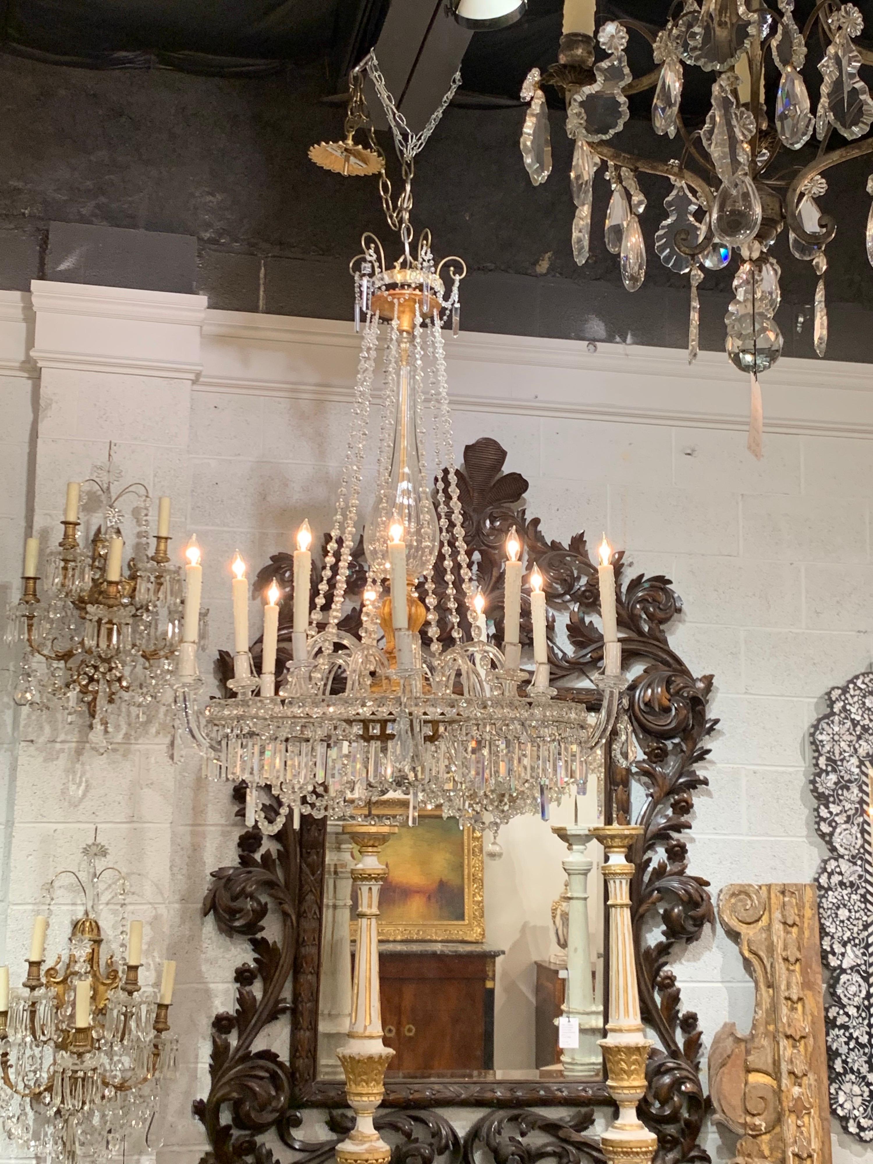 Elegant 19th century Italian giltwood and crystal chandelier with 10 lights. Pretty glass detail on the base and arms of the fixture along with gorgeous crystals. Very impressive!
