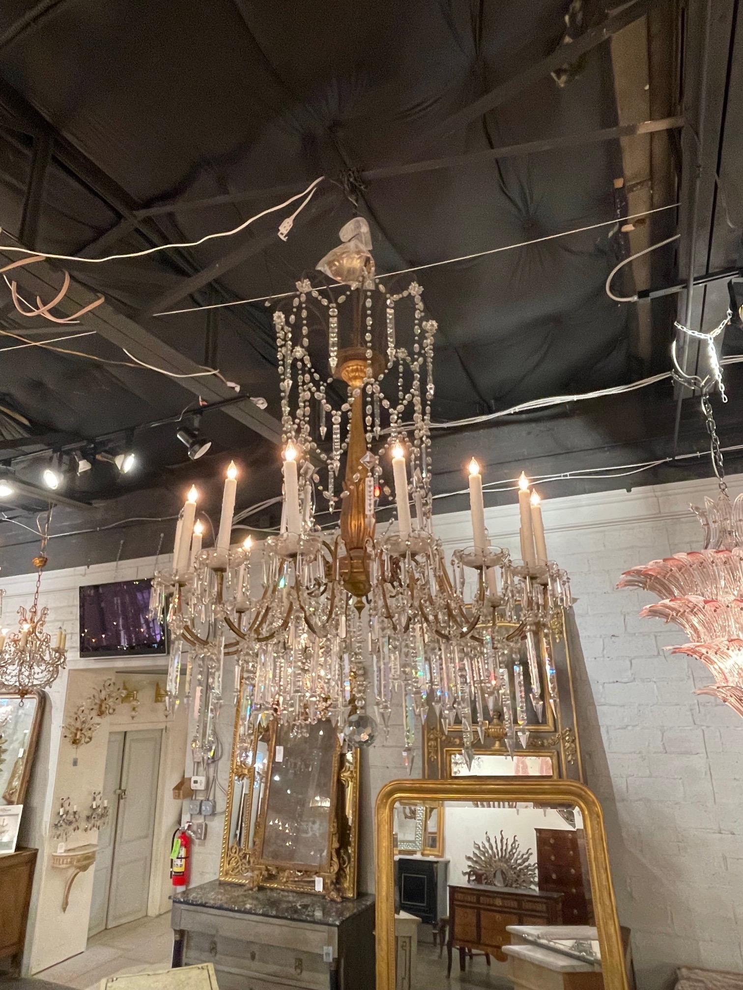 Exceptional large scale 19th century Italian giltwood and crystal 16 light chandelier. Featuring a beautiful carved base and gorgeous beads and crystals. A lovely fixture that is sure to impress!!