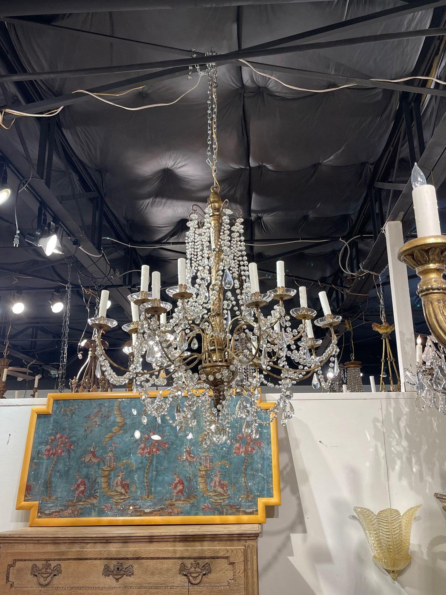 Very fine 19th century Italian giltwood and crystal chandelier with 16 lights. Featuring a beautiful carved based and a plethora of glistening crystal.  Stunning!!