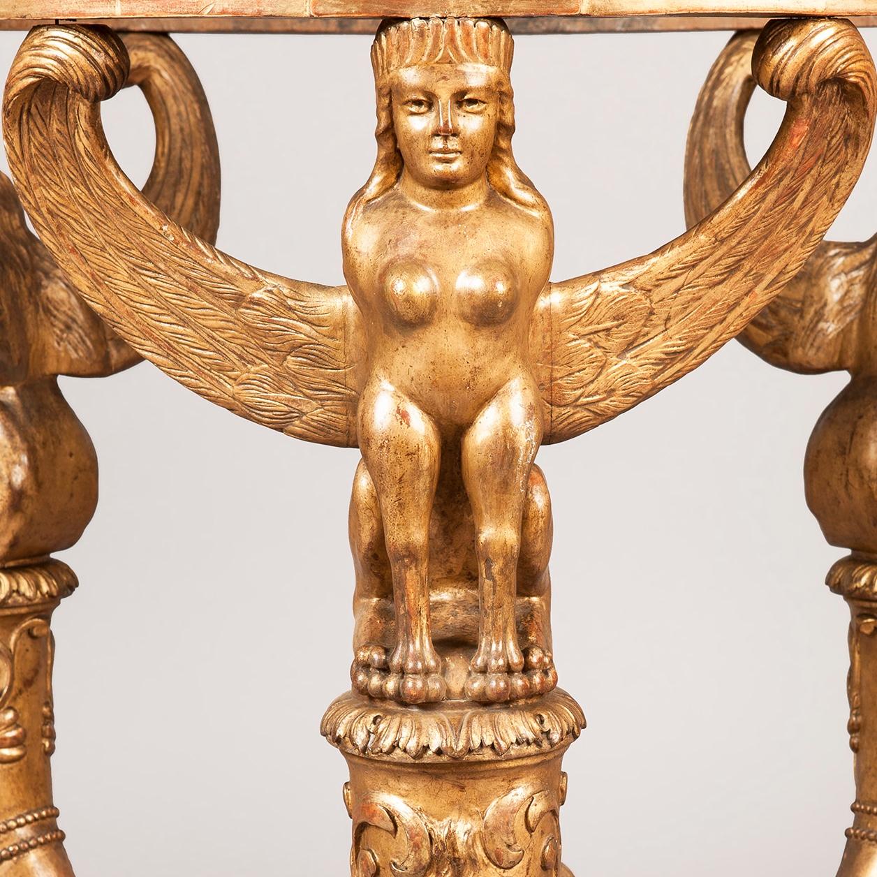 A good centre table in the Italian impero manner

Constructed in carved gold leaf giltwood, and having a St Jean brecciated marble top; of circular form, the tripartite base of canine legs terminating in hoofed feet, being dressed with satyr masks