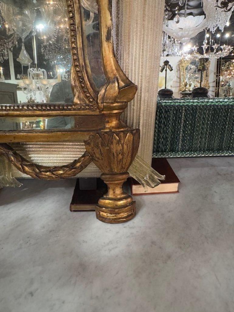 Der italienische Bogenspiegel aus Giltwood aus dem 19. Jahrhundert zeichnet sich durch eine elegante Bogenform mit komplizierten Schnitzereien aus. Dieses antike Stück strahlt Raffinesse und Charme aus und spiegelt die komplizierte Handwerkskunst