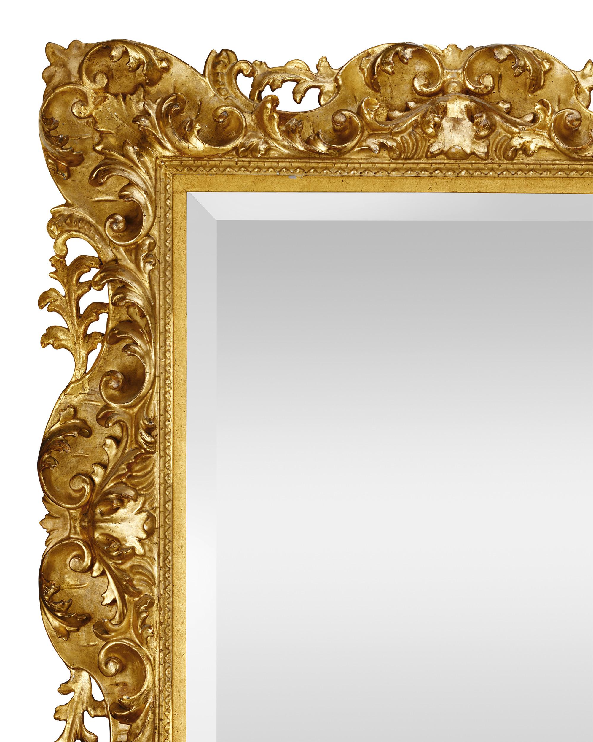 Les détails exquis de ce miroir en bois doré italien sculpté à la main n'ont d'égal que sa taille considérable. Haut de près d'un mètre et large d'un mètre, ce miroir est un extraordinaire régal pour les yeux. Également connue sous le nom de 