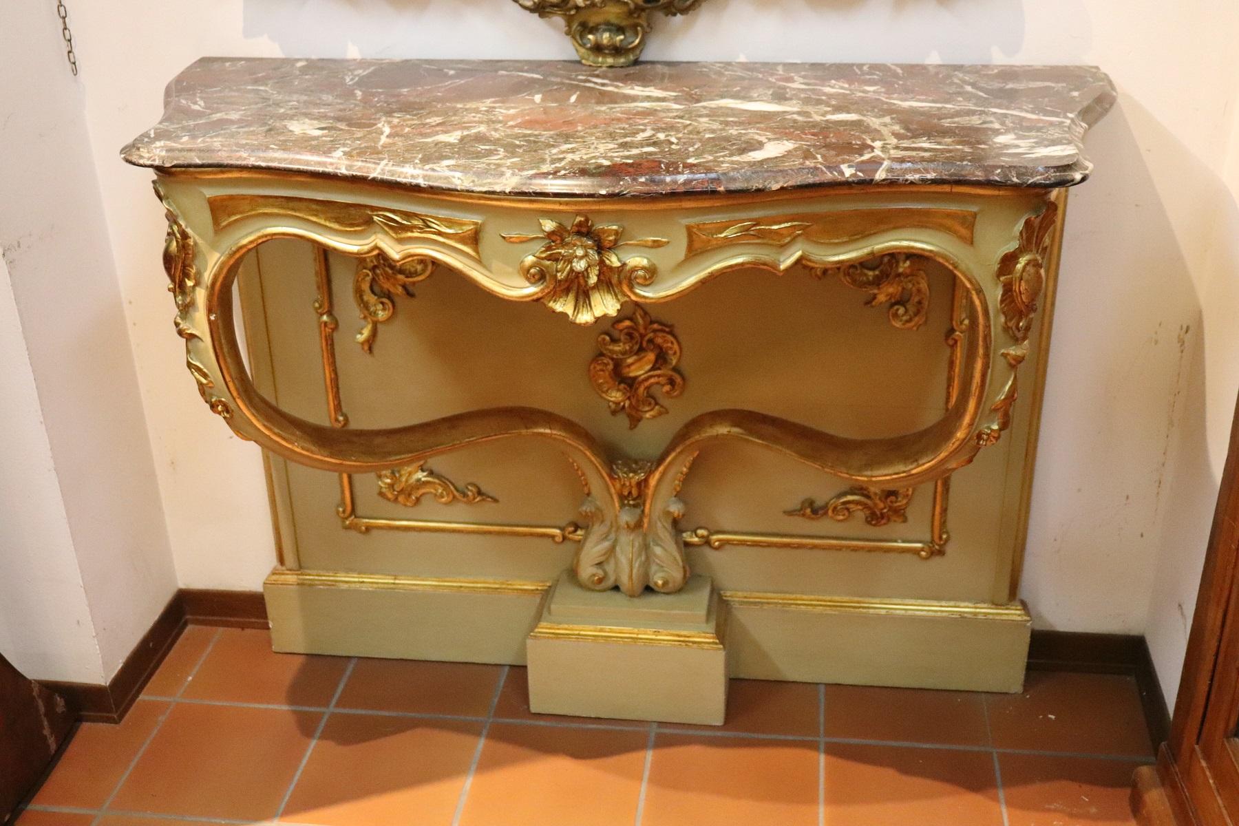 Italian antique console table, 1840. Characterized by precious lacquered and Gilded. Fine gray Italian marble top with red bordeaux veins. The wood is finely decorated with carving with moved front legs. Beautiful elegant ideal for the entrance of