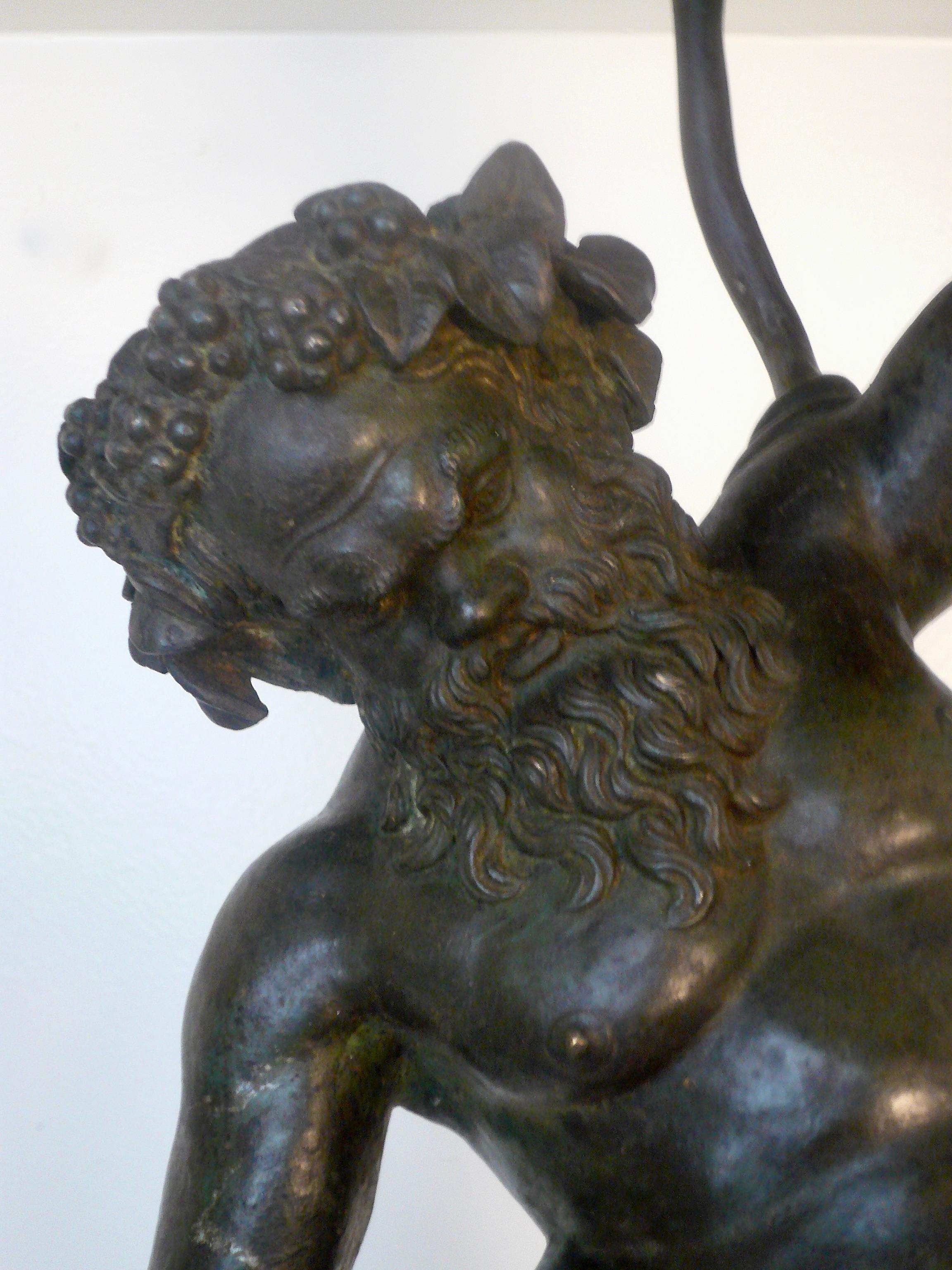 This 19th Century bronze figure of Silenus, God of wine, and tutor of Dionysus, is depicted wrestling a serpent. The serpent represented wisdom and eternal life to the Ancients. It is modeled after the sculpture found at Pompeii excavated in 1864,