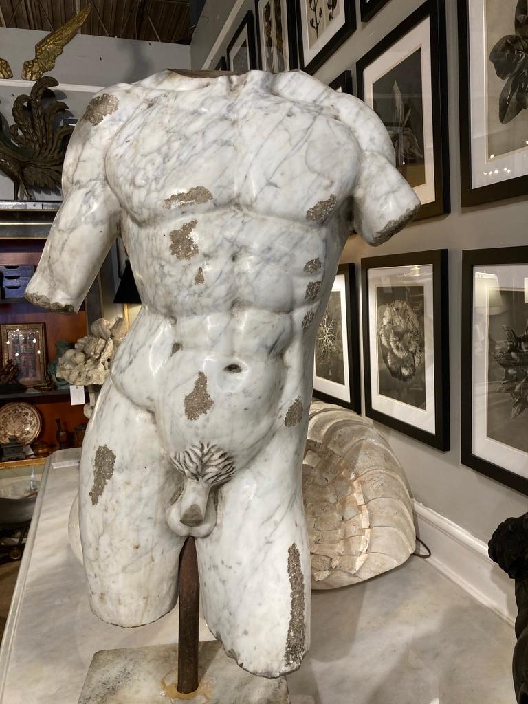 An Italian marble torso of a naked god or warrior in the ancient Roman style. Beautifully carved from gray veined white marble with distressed areas to mimic and excavated classical sculpture. Grand Tour period, late 19th century. 
Impressive scale