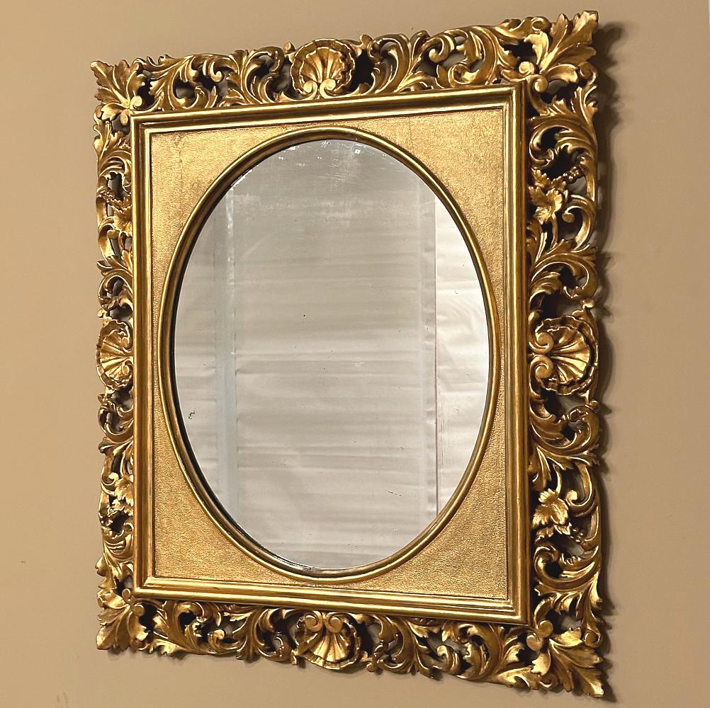 Ce miroir en bois doré italien du XIXe siècle, sculpté à la main, est un merveilleux témoignage du talent des artisans qui l'ont créé.  Combinant un cadre rectangulaire et un miroir ovale pour un look unique, il a été créé en sculptant à la main le