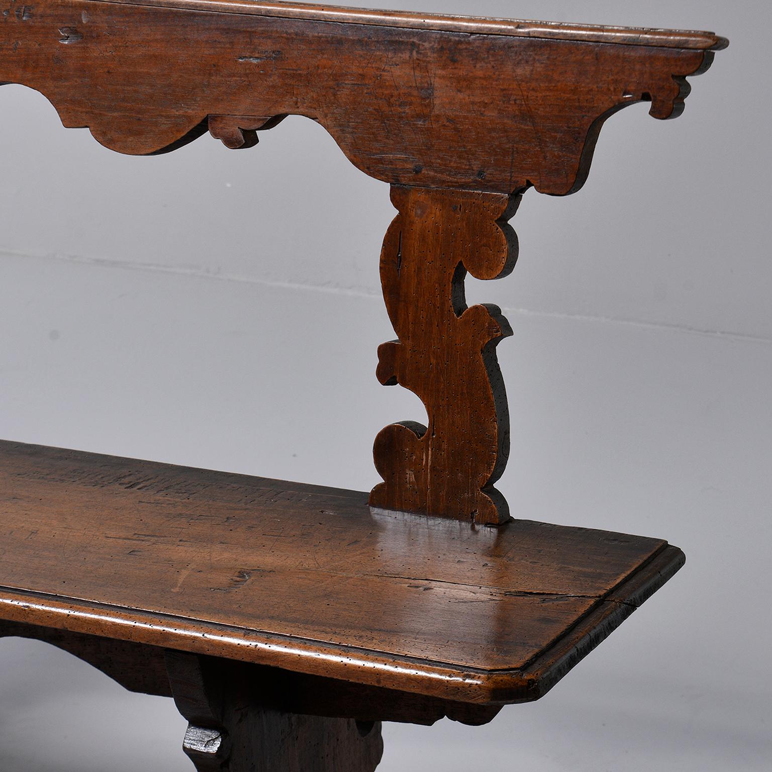 Italian wooden bench features hand carved details on the top back rail, leg supports and apron, circa 1880s. Unknown maker and wood.