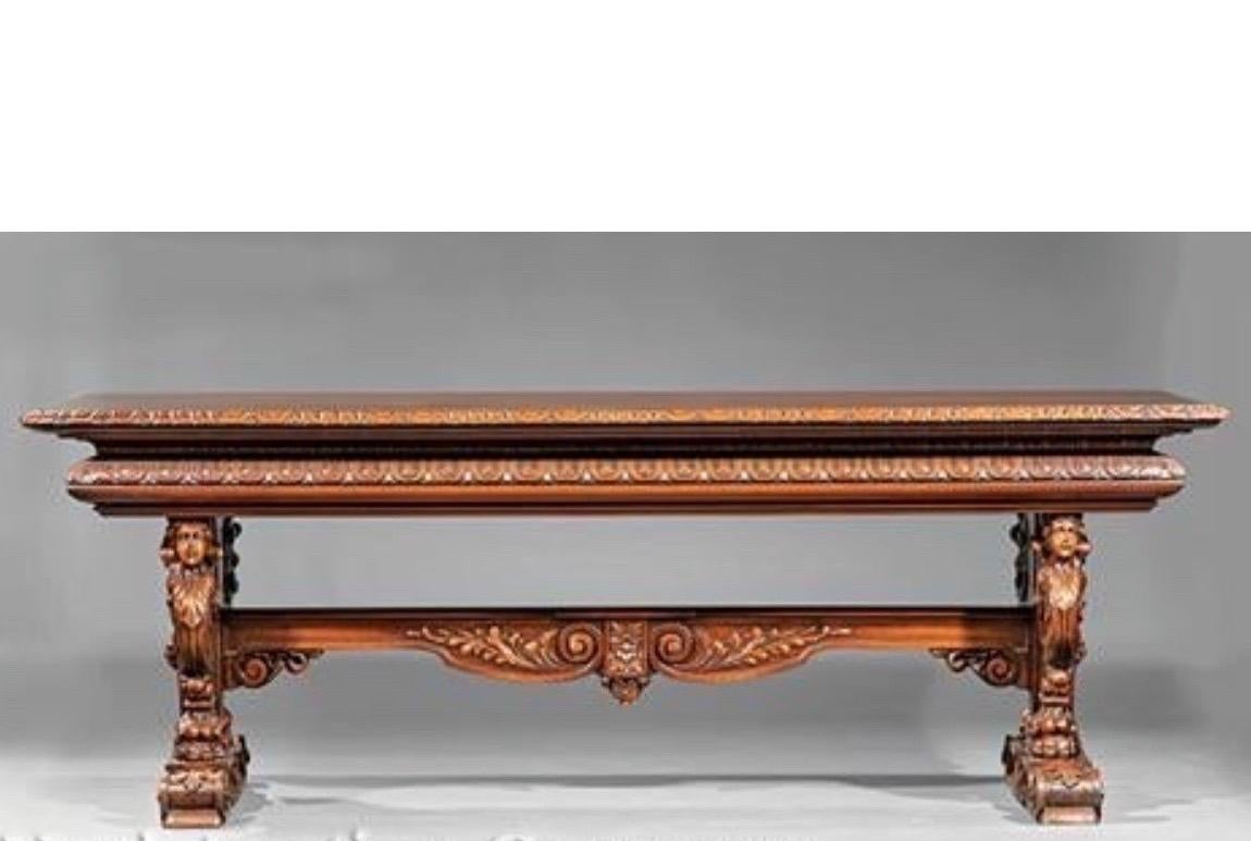 19th century Italian hand carved walnut table. Top with scalloped border and frieze, robustly carved scrolled supports decorated with masks and paw feet, shaped foliate stretcher, scrolled feet.
