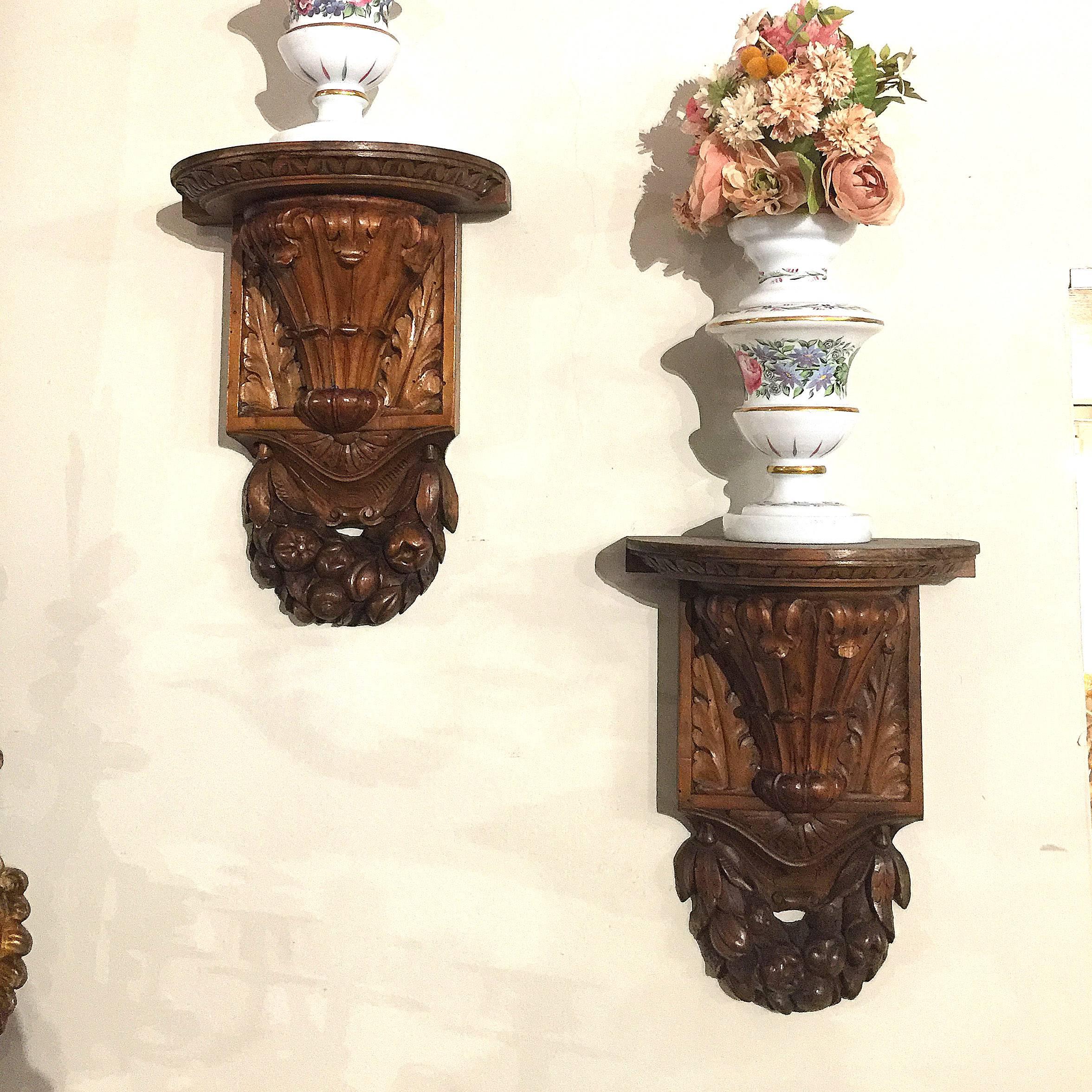 Fine pair of antique Italian walnut wood wall brackets.
Hand-carved, of demilune form, featuring acanthus leaves and garlands of fruit.
The decorative consoles are in excellent condition and have a rich walnut patina.
Pair of charming