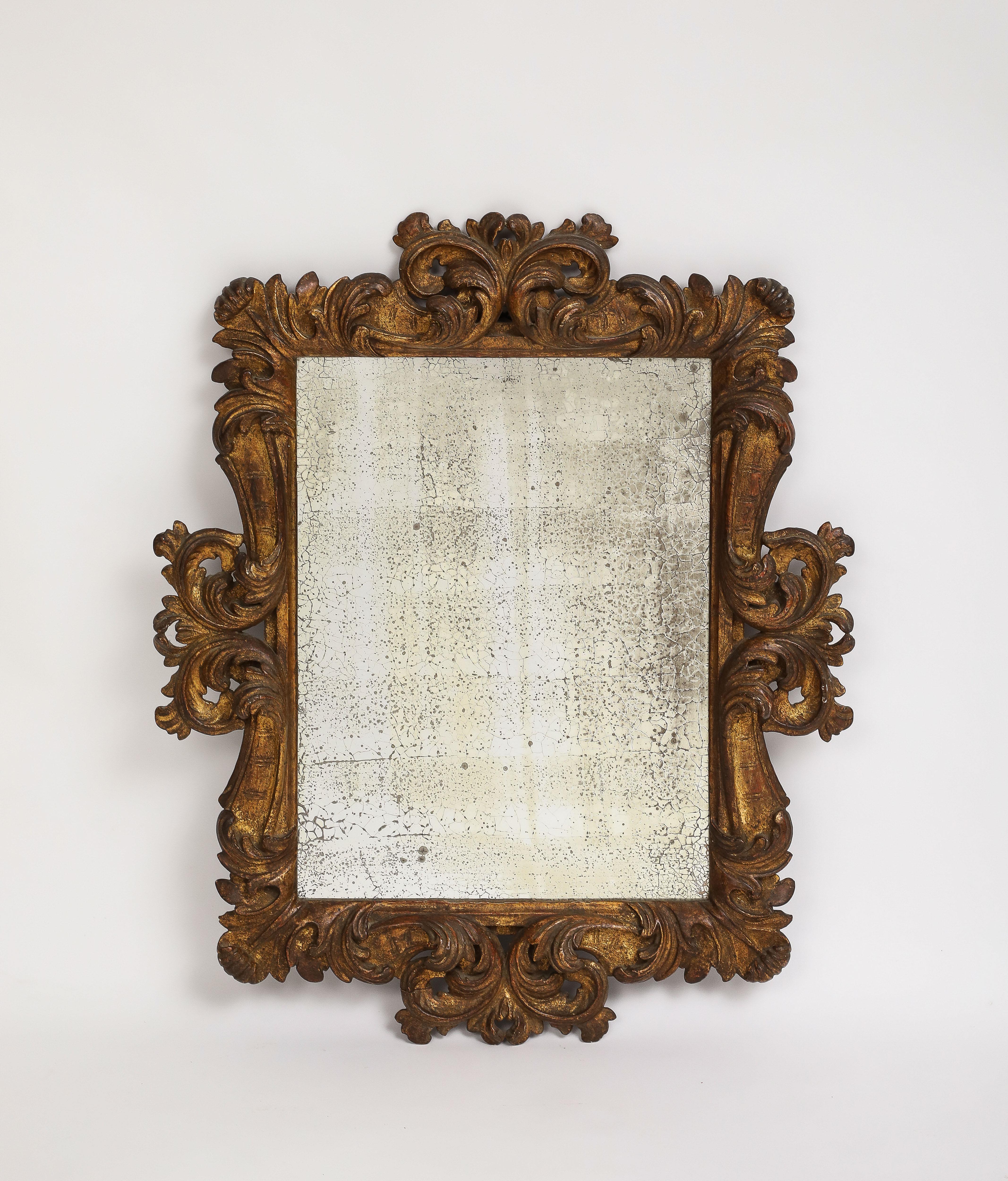 Italienischer, handgeschnitzter, blattförmiger Wandspiegel aus Holz vom Ende des 19. Jahrhunderts, eingesetzt mit antikem Spiegelglas. Keine Verluste an der Vergoldung, Schlaufe auf der Rückseite zum Aufhängen. 