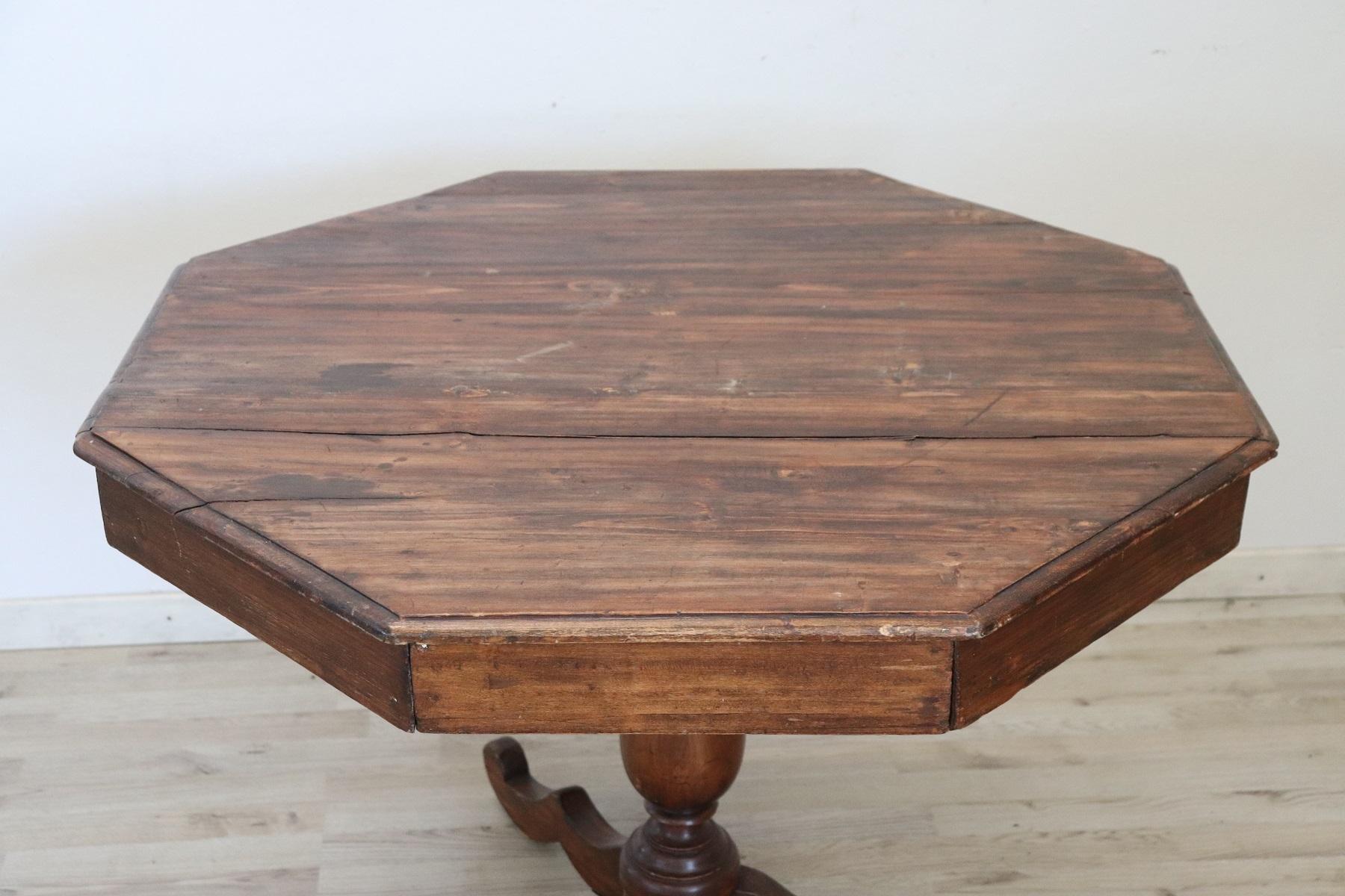 Beautiful antique hexagonal center table, 1850s in poplar wood. The plan presents glass top. The central leg is finely turned.
The antique table have been used in need of restoration as you can see from the wear defects in photos. We can provide in