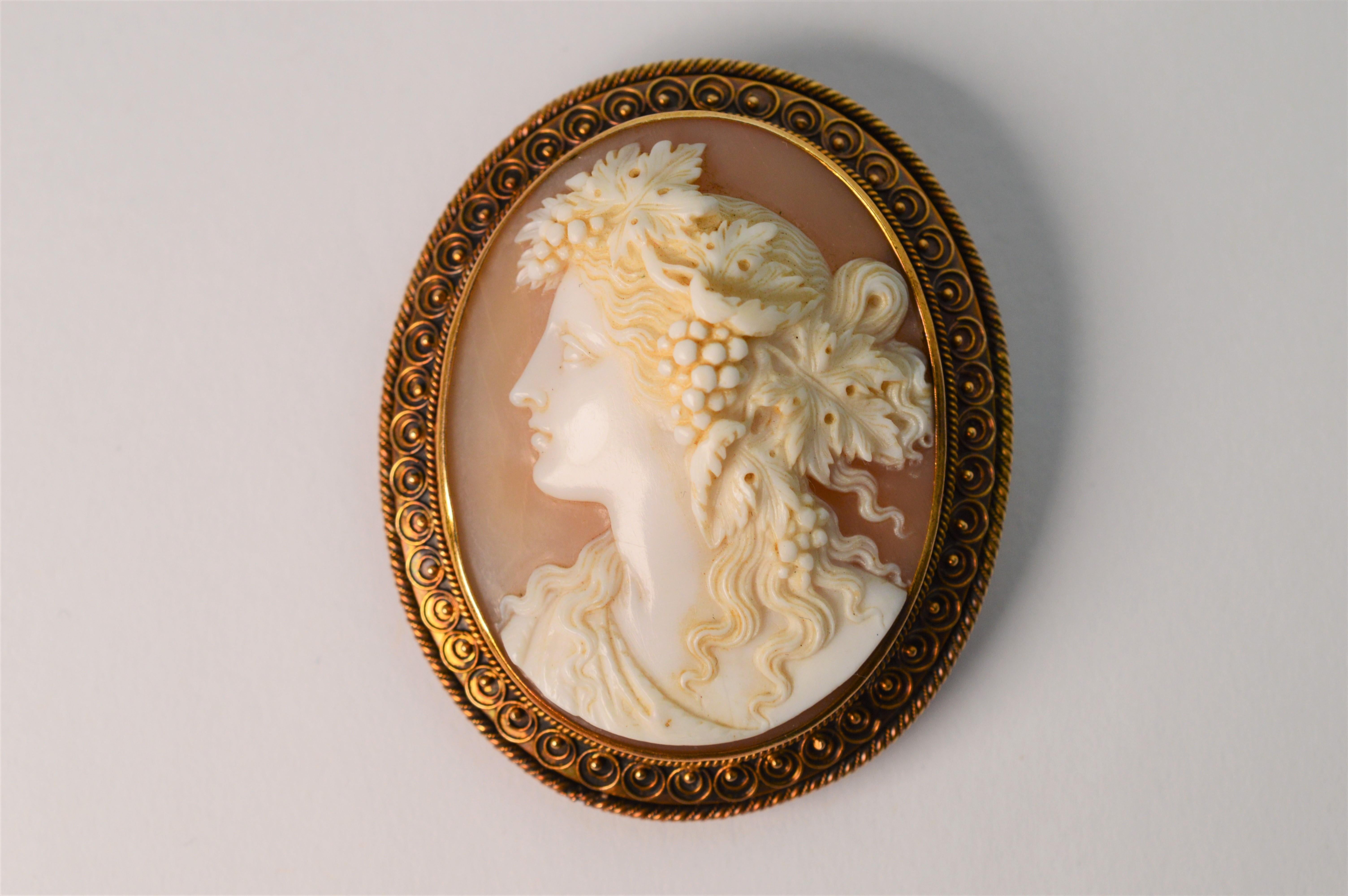 Finely hand carved in high relief with exquisite detail, this pre 1900 high art Italian made shell cameo brooch displays the pose of a Contessa with beautiful flowing hair elegantly adorned with flora. 
This fine oval carving is framed in eighteen