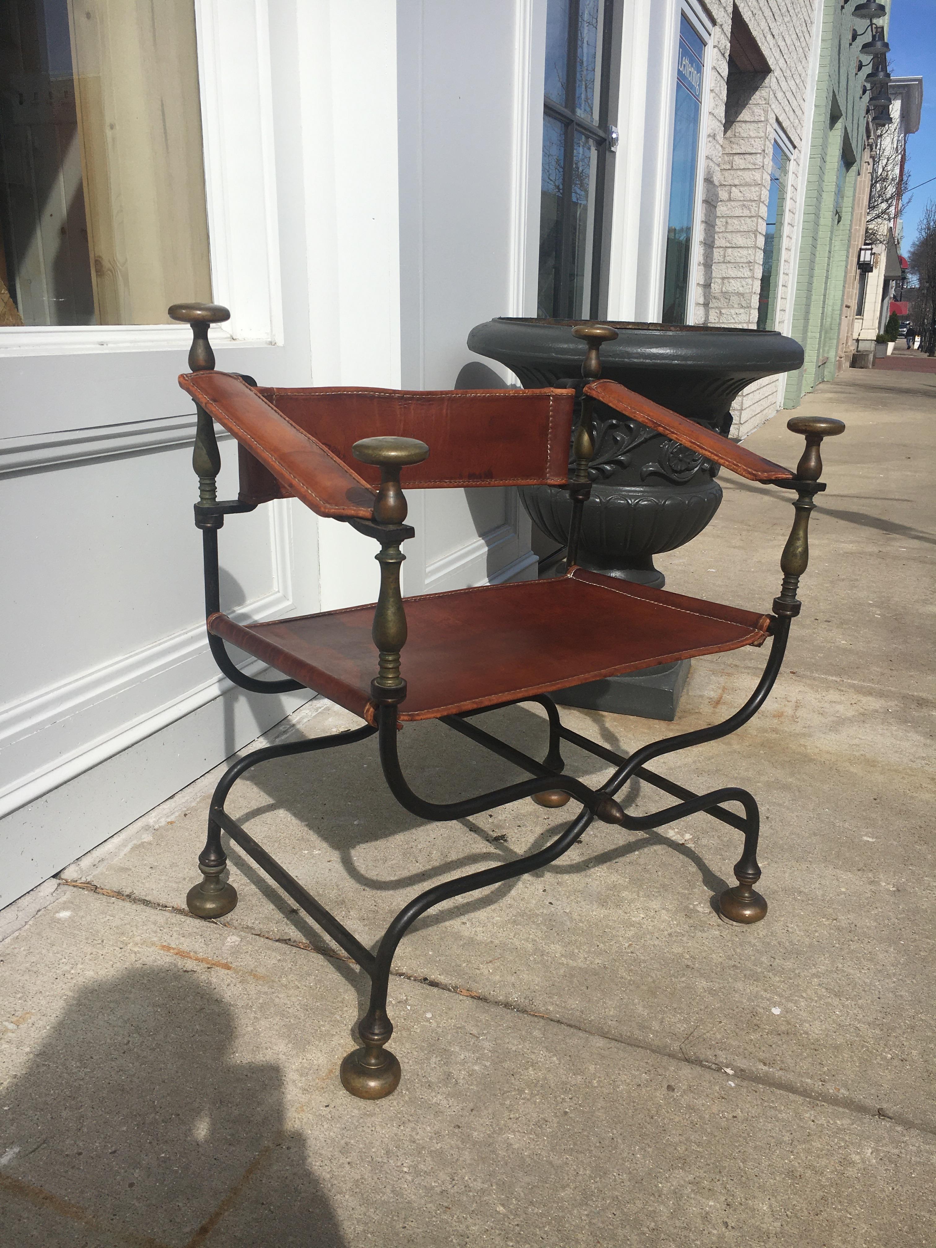Stunning Italian iron and brass Savonarola Dante chair also known as x chairs or Curule chairs. Featuring a scissor form iron frame that folds in a Campaign style with bronze-mounted finials and feet. The seat, back, and arms are upholstered with
