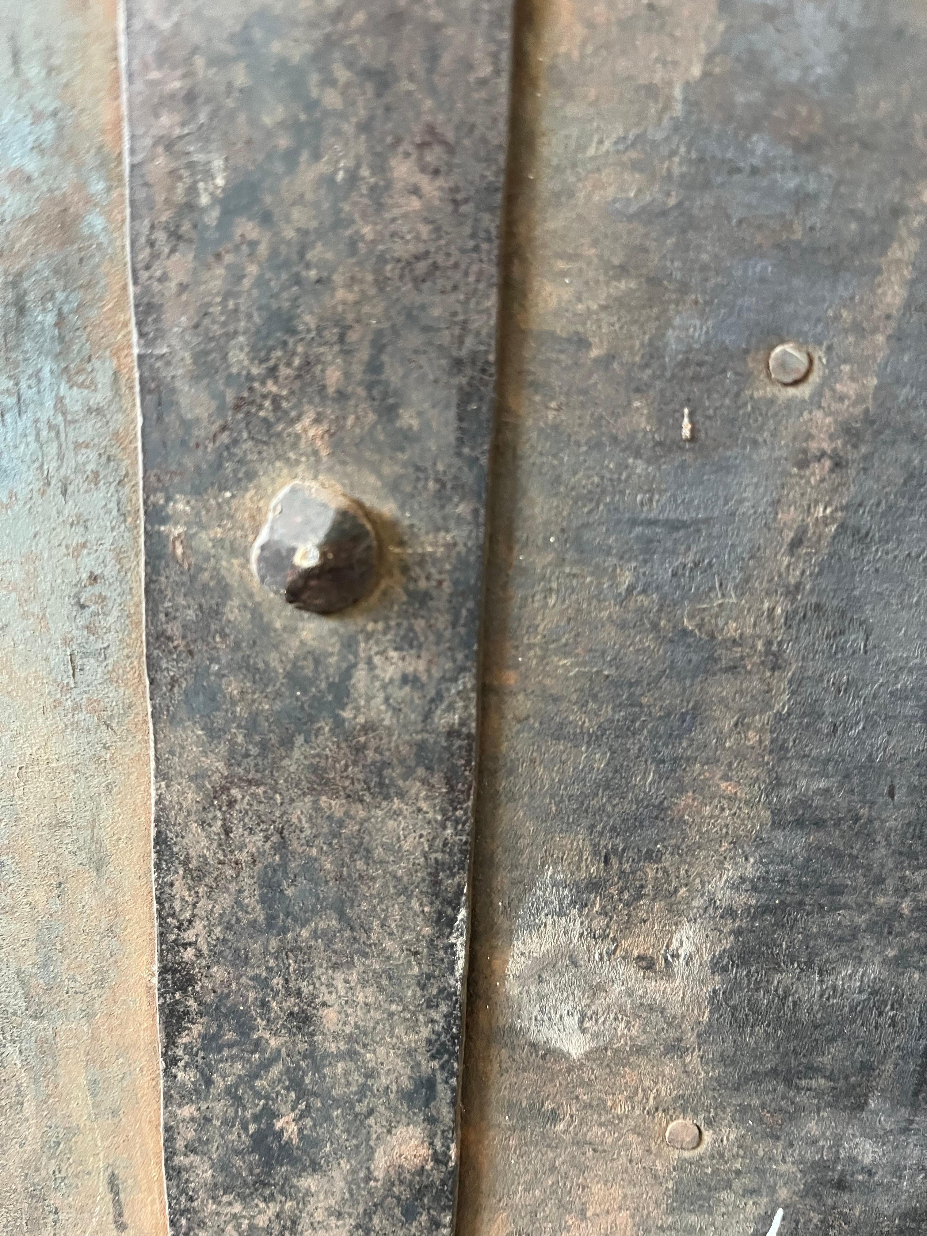 Hand-wrought iron safe hand-made in Italy in the early 1800s. The safe is made of thin sheets of iron folded and nailed together over a wooden case. Thicker bands of iron were then used to consolidate the structure. On the front the safe has a