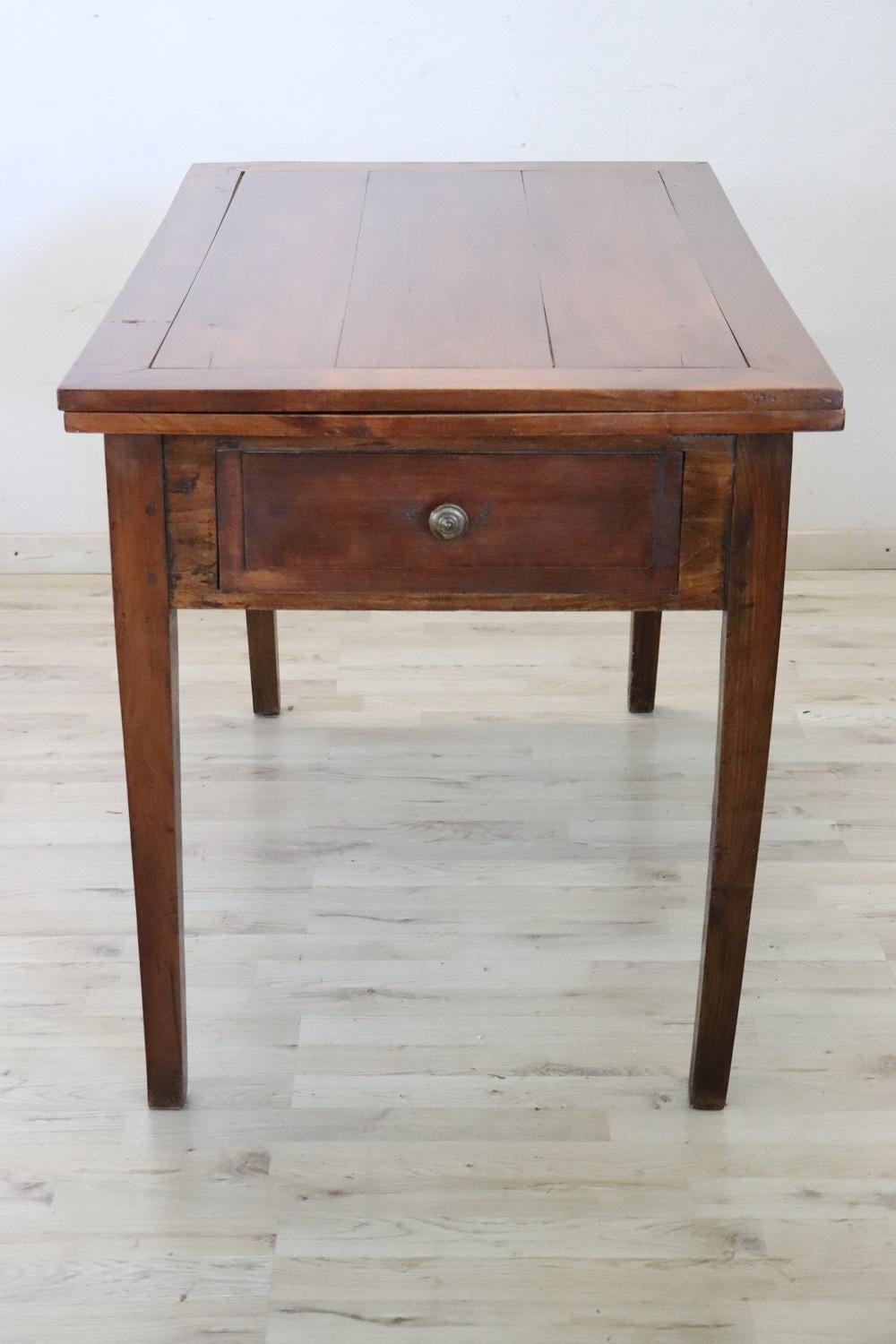 Beautiful very nice Italian solid poplar and cherry wood kitchen table, 1850s. The table is very simple and linear, characterized by solid straight legs. Equipped with a drawer and a practical internal compartment. The top of this table opens like a