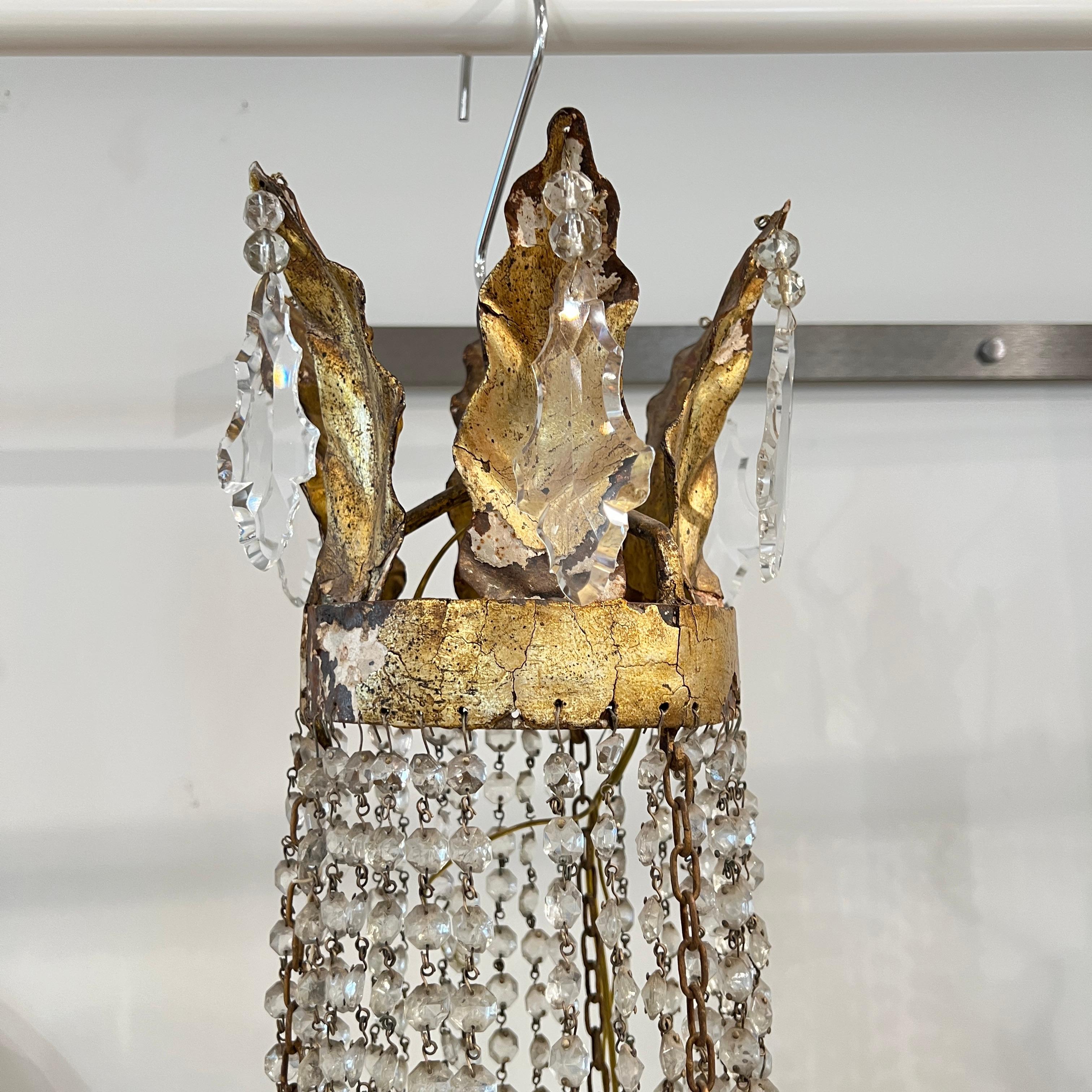 Una gran araña Imperio del siglo XIX con cascadas de cristal tallado a mano y un marco de hierro ricamente dorado, que muestra la simetría clásica y la opulencia del diseño napoleónico.
Debe estar cableado para EE.UU.