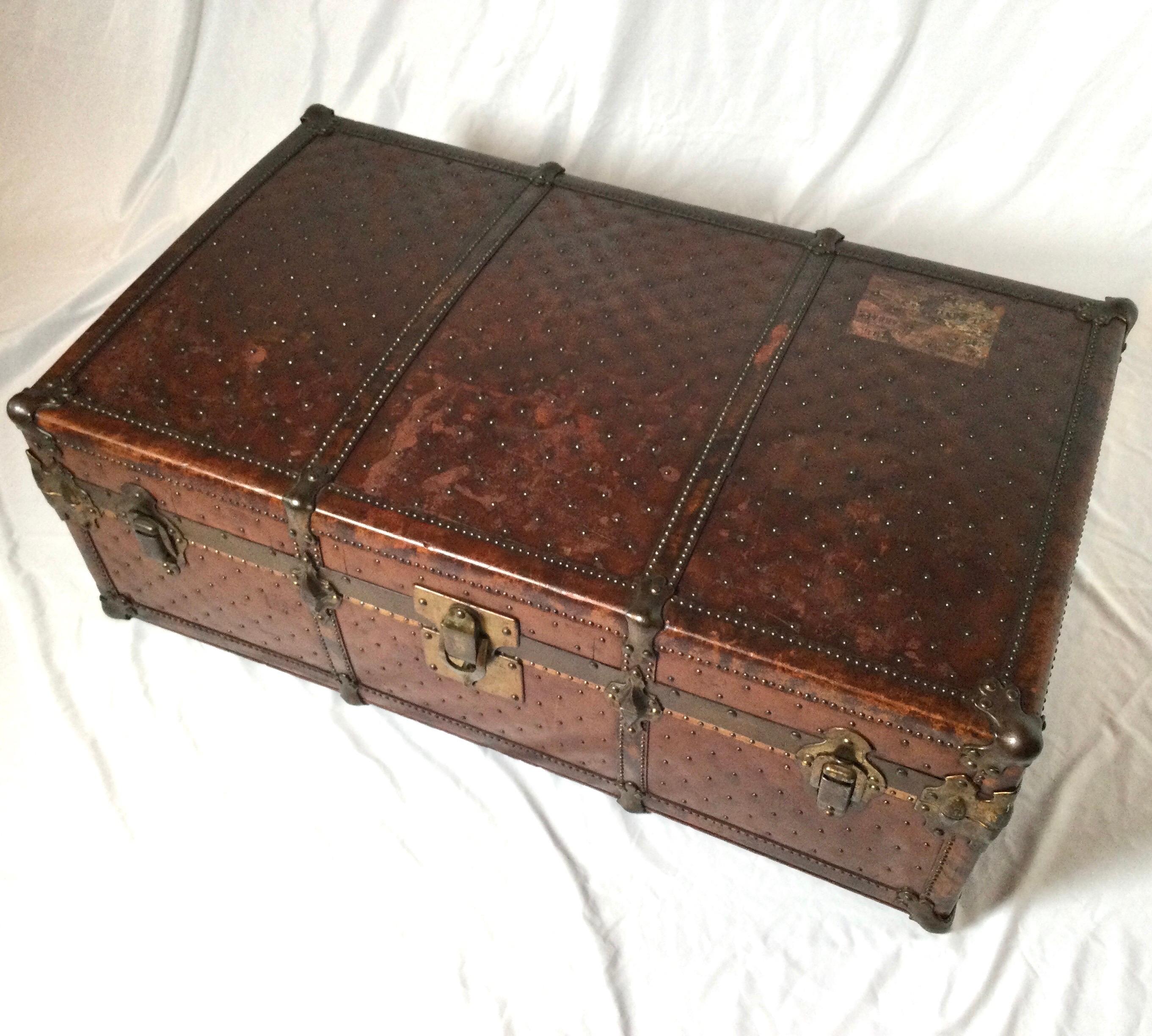A 19th century Italian leather trunk with metal studs decorating the exterior, original riveted hardware, linen interior, brass hinges. There are remnants of two decals from travel.