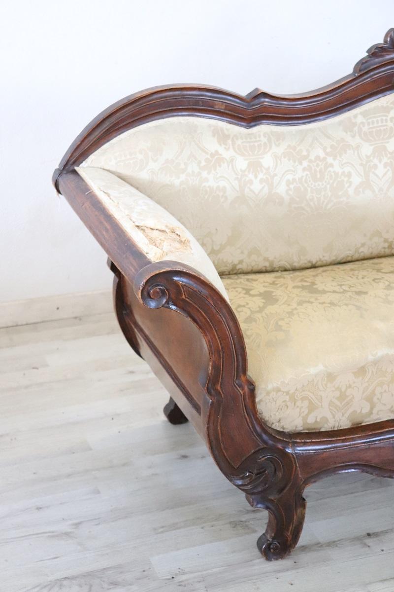 Italian Antique settee circa 1845 of the period Louis Philippe. The settee is made of solid walnut wood hand carved.  In good antique conditions of the wood. Particular wavy shape. The advantageous price is due to the necessary replacement of the