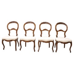 Set di quattro sedie antiche in legno di noce intagliato Louis Philippe del XIX secolo