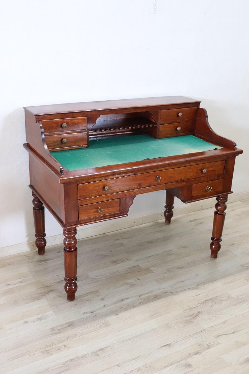 Elegant antique Italian writing desk. Rare and precious solid cherry wood. Comfortable size for a practical use. The desk has elegant turned legs. In the lower part three drawers and in the upper part four smaller drawers with a curious little shelf