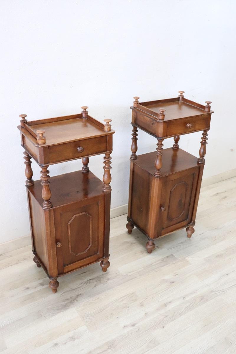 Lovely antique Italian pair of nightstands of the period Louis Philippe, 19th century in solid walnut wood. The nightstands very refined linear and elegant with on the front decorative turned columns. On the front one-drawer and one-door. Very