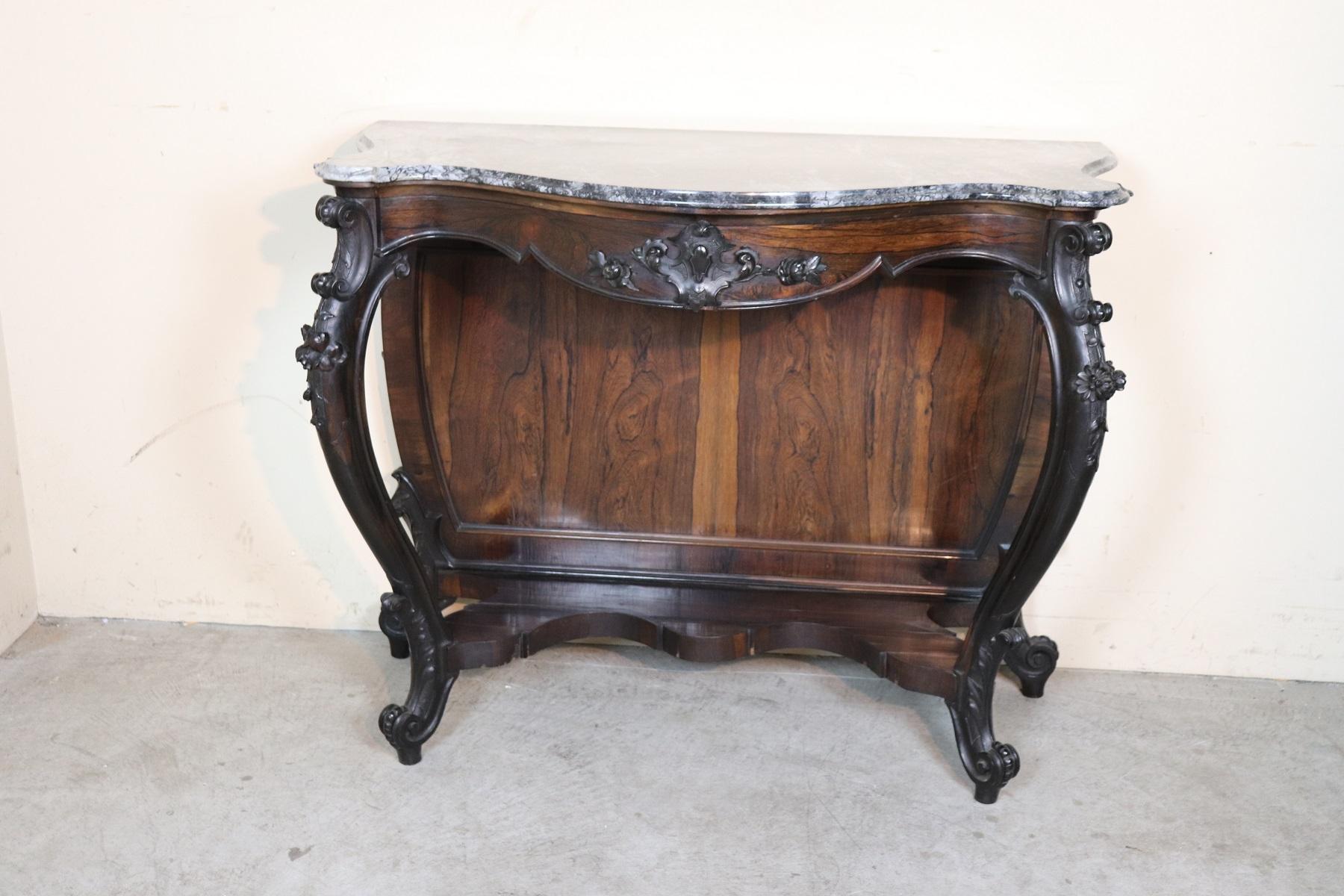 Italian antique console table, circa 1845. Characterized by precious rosewood with wood carving. Refined Genovese carving work performed by an important cabinet maker. Look at the front legs moved enriched with scrolls and flowers carved in the
