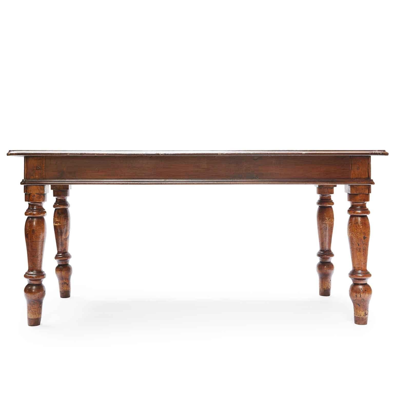 19th century Italian Lombard dining room center table made of solid walnut, rectangular top, one deep drawer on the long side, and two drawers on the short sides, alder turned legs.
In good condition, this antique Italian table dates back to the