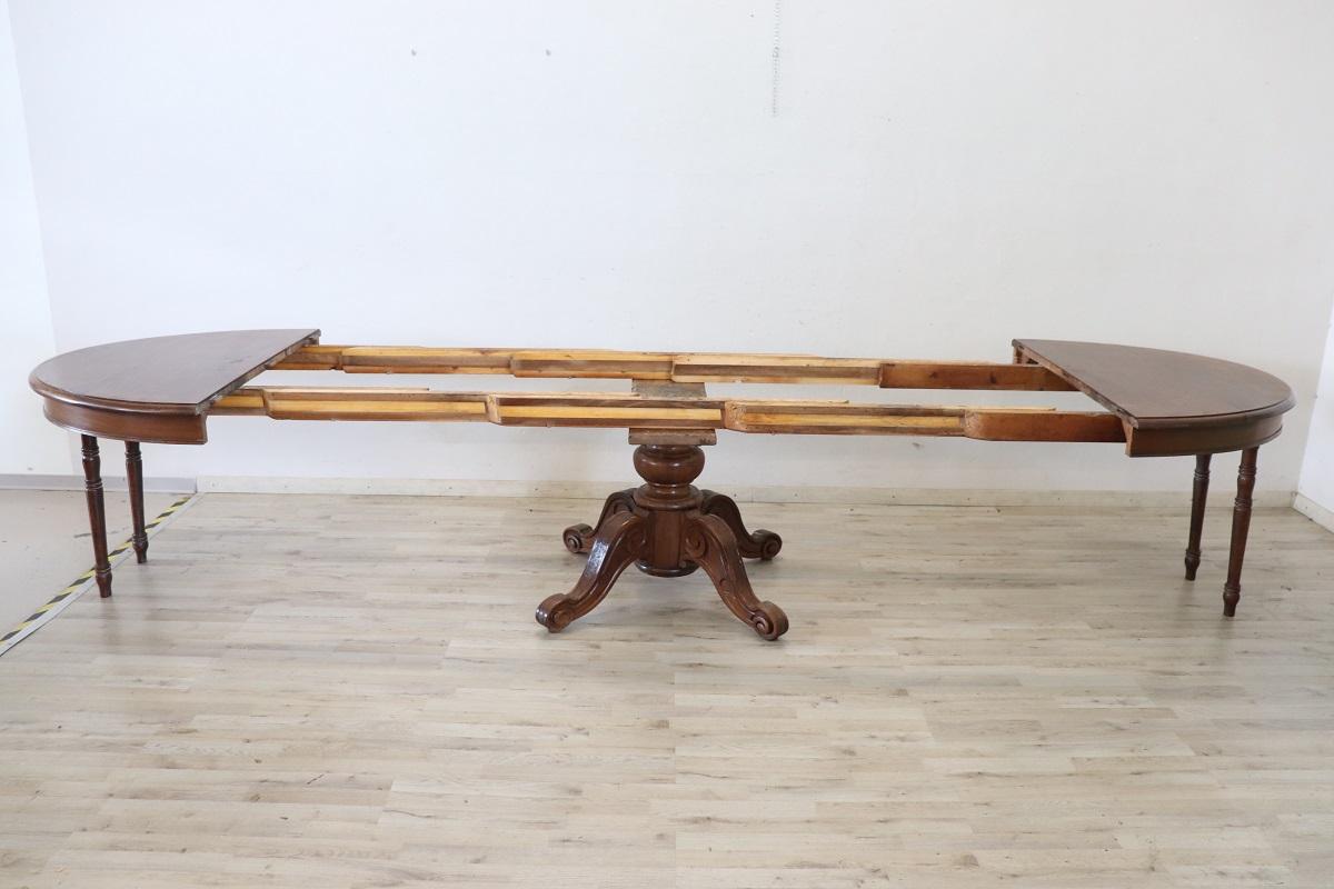 Beautiful important antique oval large dining room table, 1840 in solid walnut wood. This table is perfect for a dining room, it extends into the center becoming a large table that can accommodate many people. The large central leg is finely turned