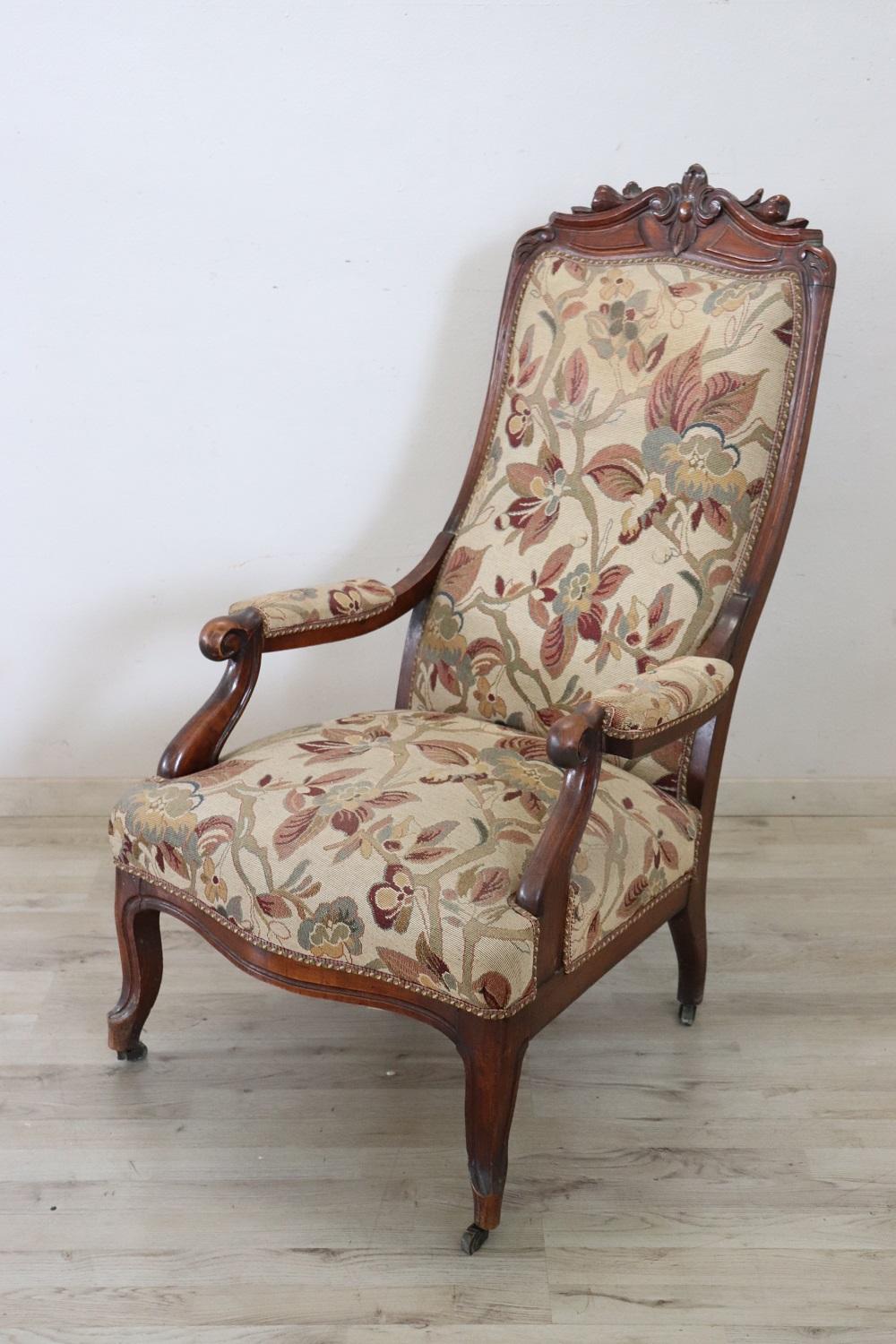 Lovely Italian antique armchair in solid walnut. This beautiful armchair has an enveloping shape and a comfortable seat. The enveloping and relaxing backrest. Padding and wood in perfect condition but defects in the fabric, stains and a small hole